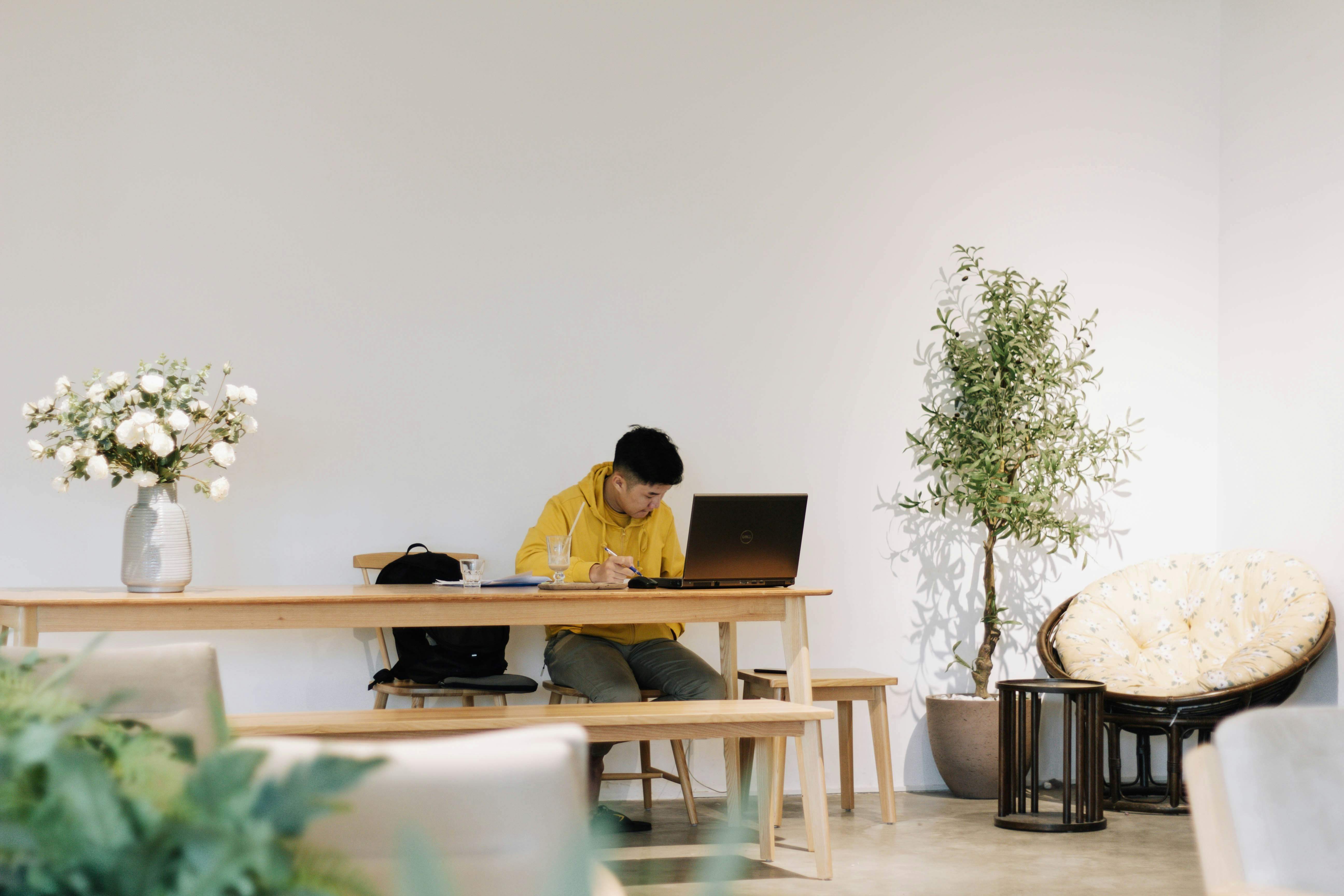 Photo by Unsplash An illustrative photo of a man in yellow shirt sitting on chair in front of laptop computer