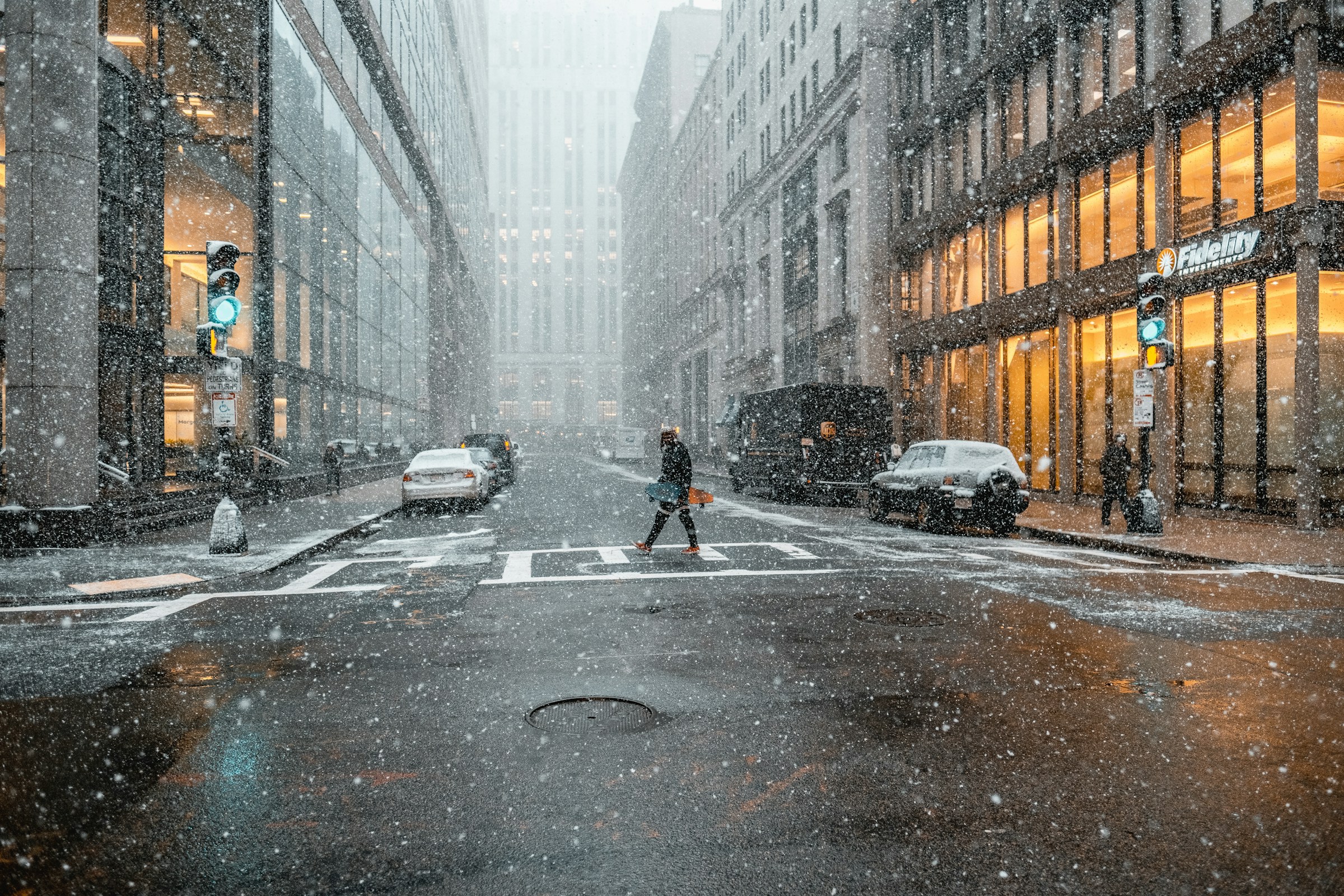 An illustrative photo of a person walking on a pedestrian lane near vehicles.