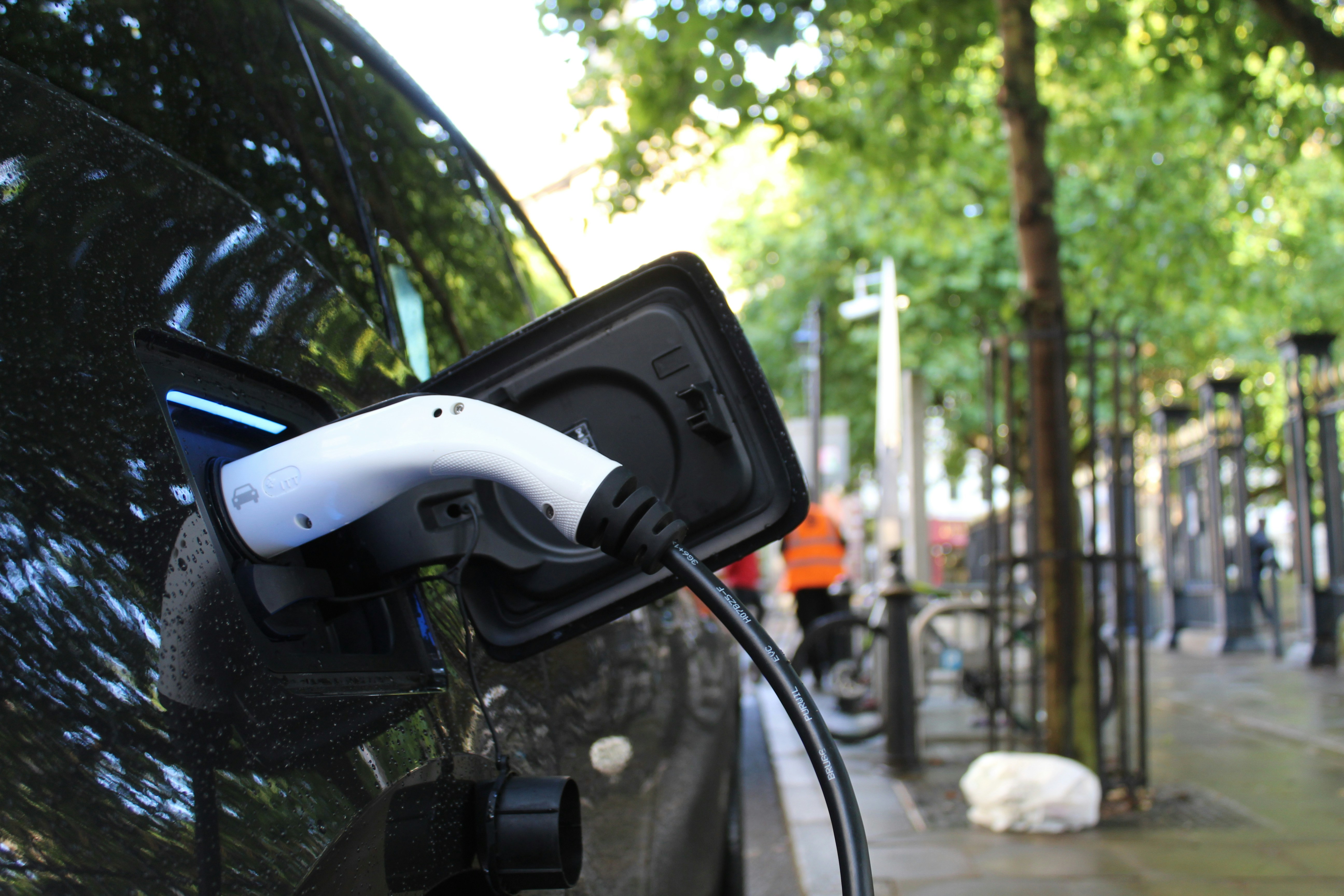 An illustrative photo of a black electric car charging