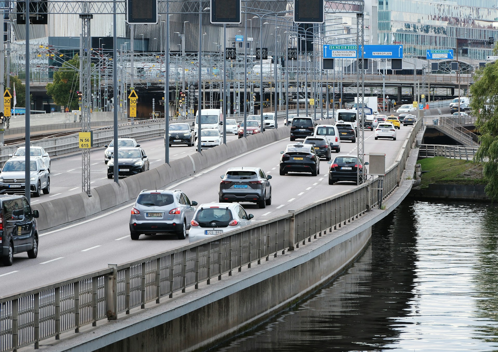 An illustrative photo of a highway filled with lots of traffic next to a river