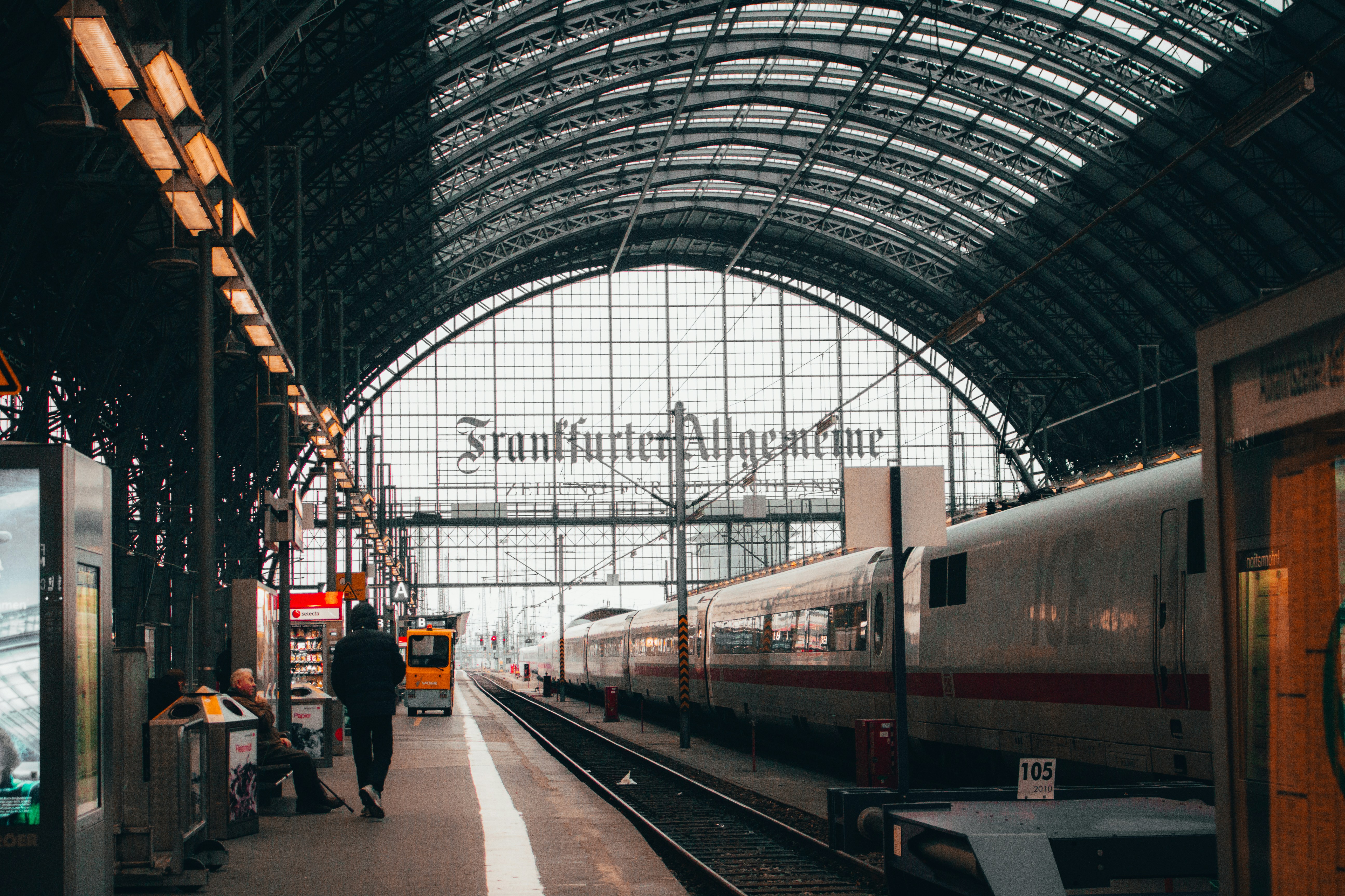 An illustrative photo of people standing near train.