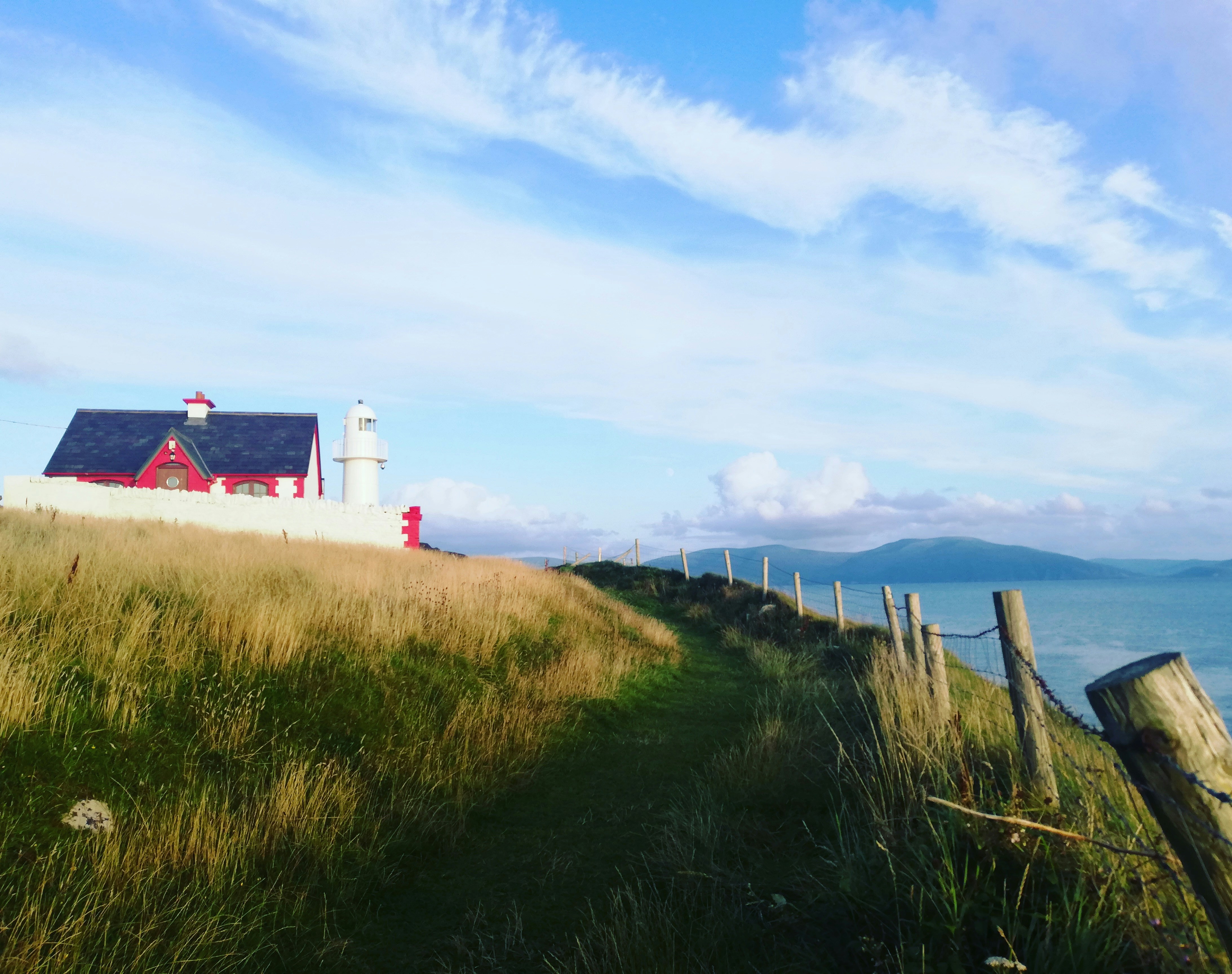 An illustrative photo of a lighthouse near green grass field.