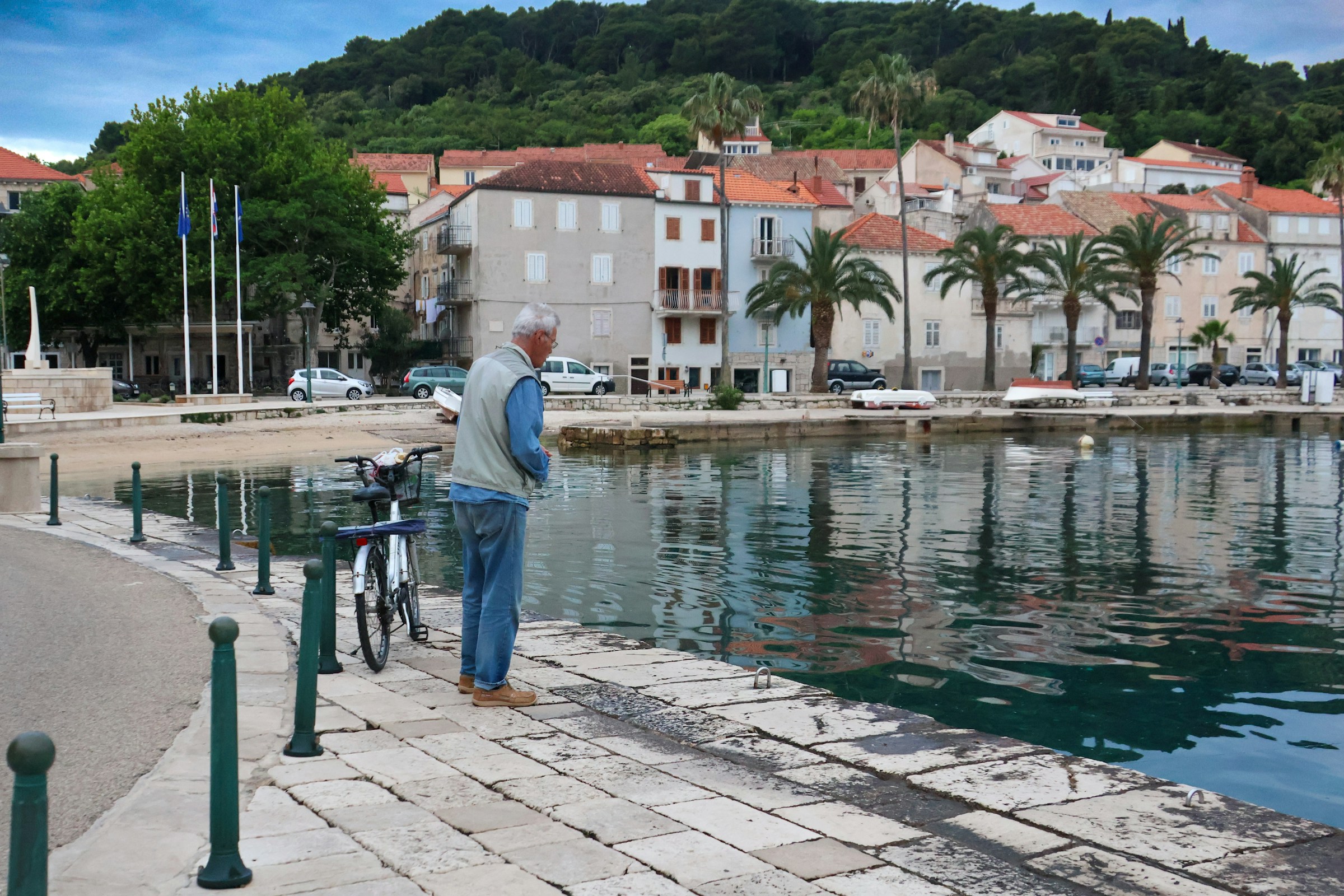 An illustrative photo of a man standing next to a bike.