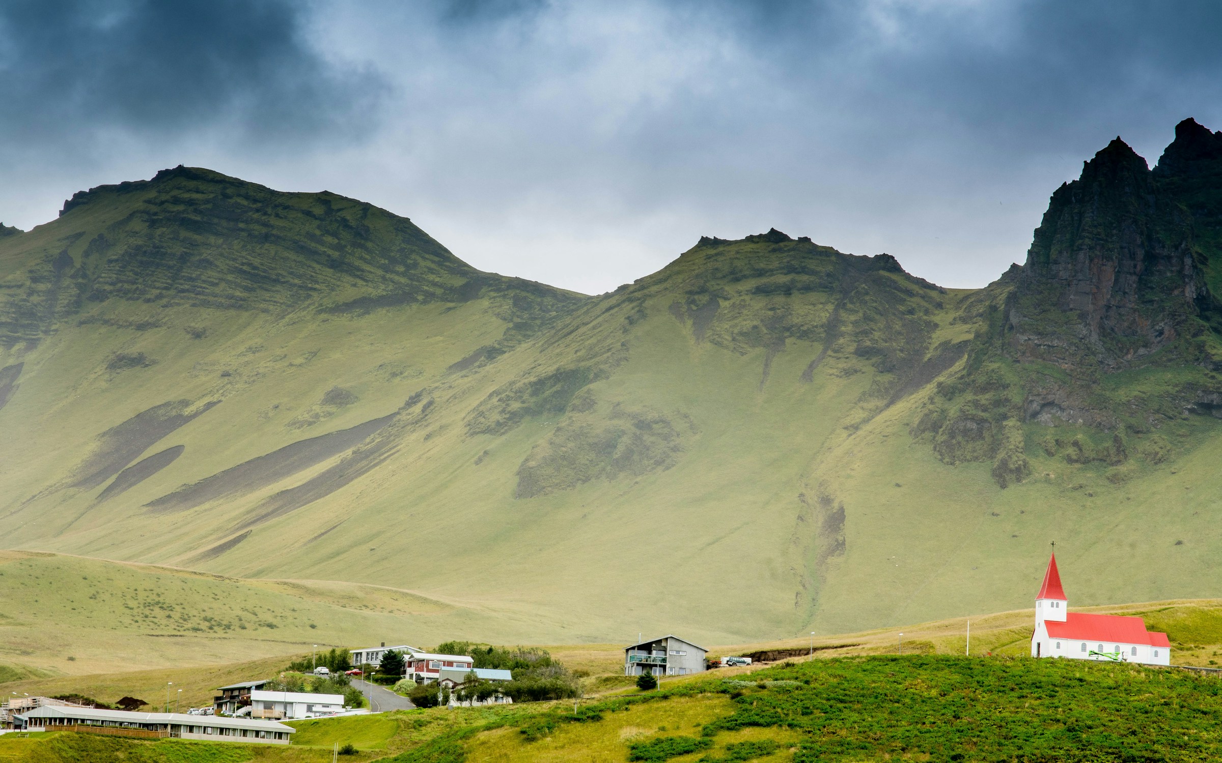 An illustrative photo of houses near hills.