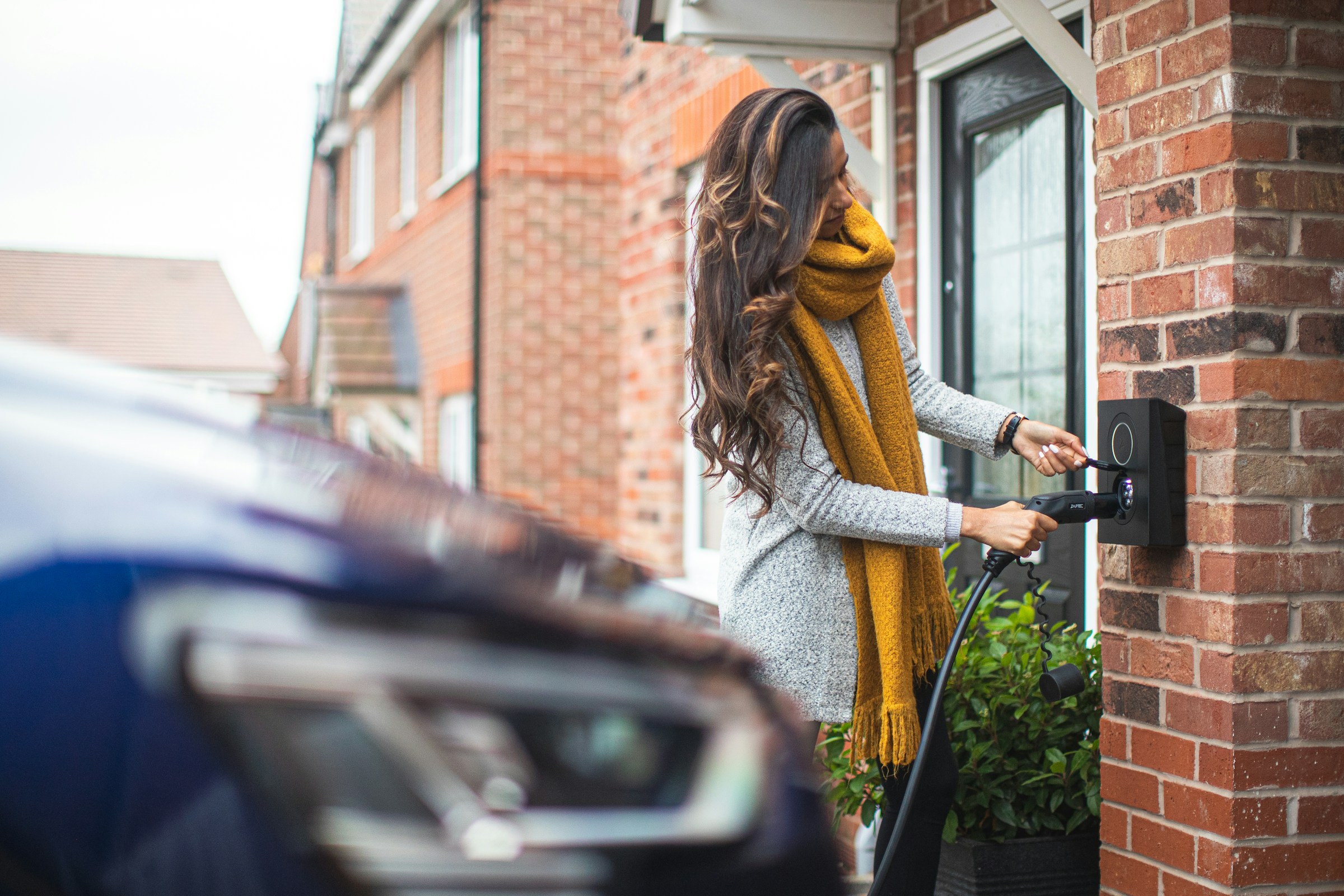 An illustrative photo of a woman charging a car.