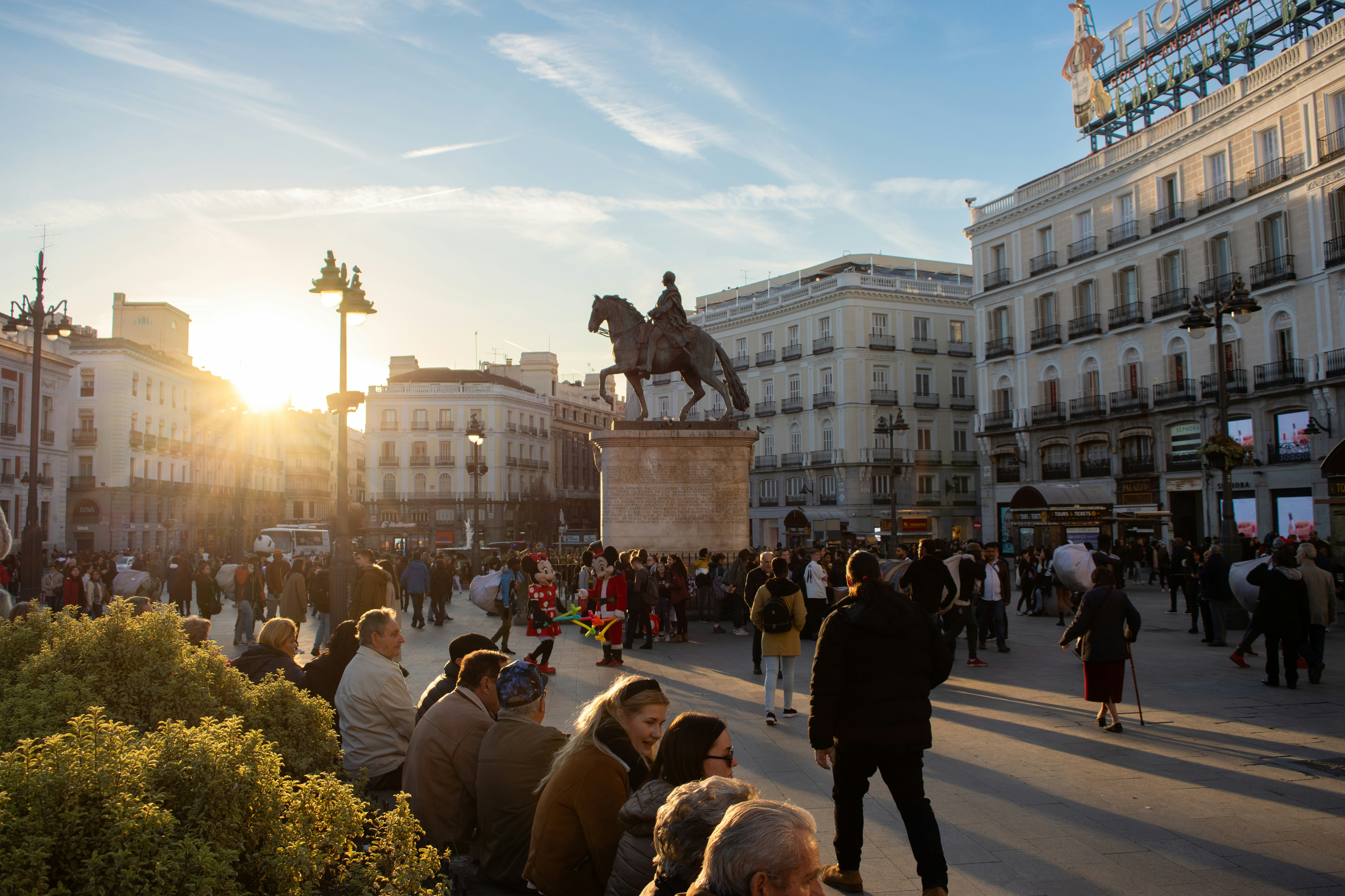 An illustrative photo of people walking on a square during sunny weather.