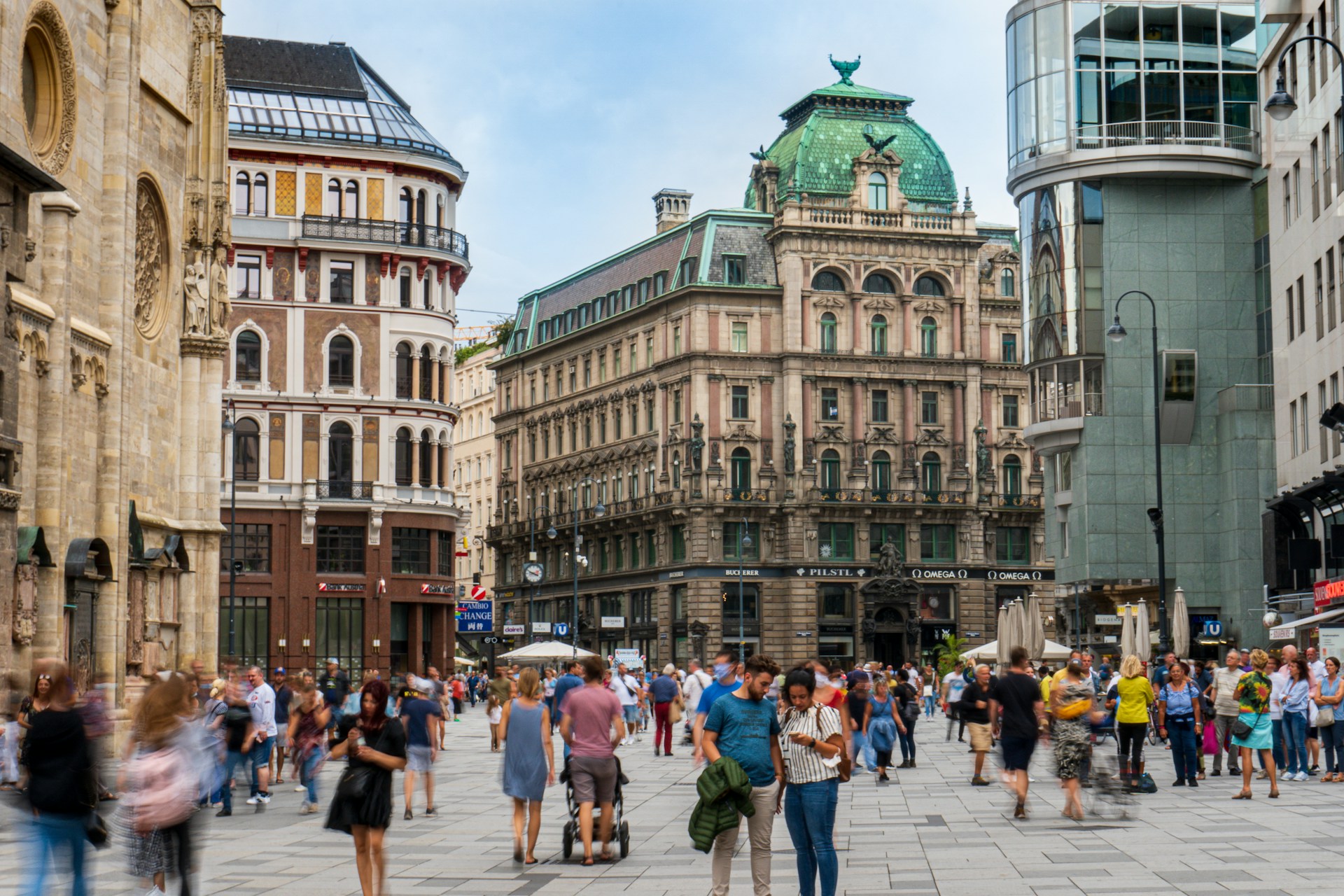 Photo by Unsplash An illustrative photo of people walking on a central street near beautiful buildings