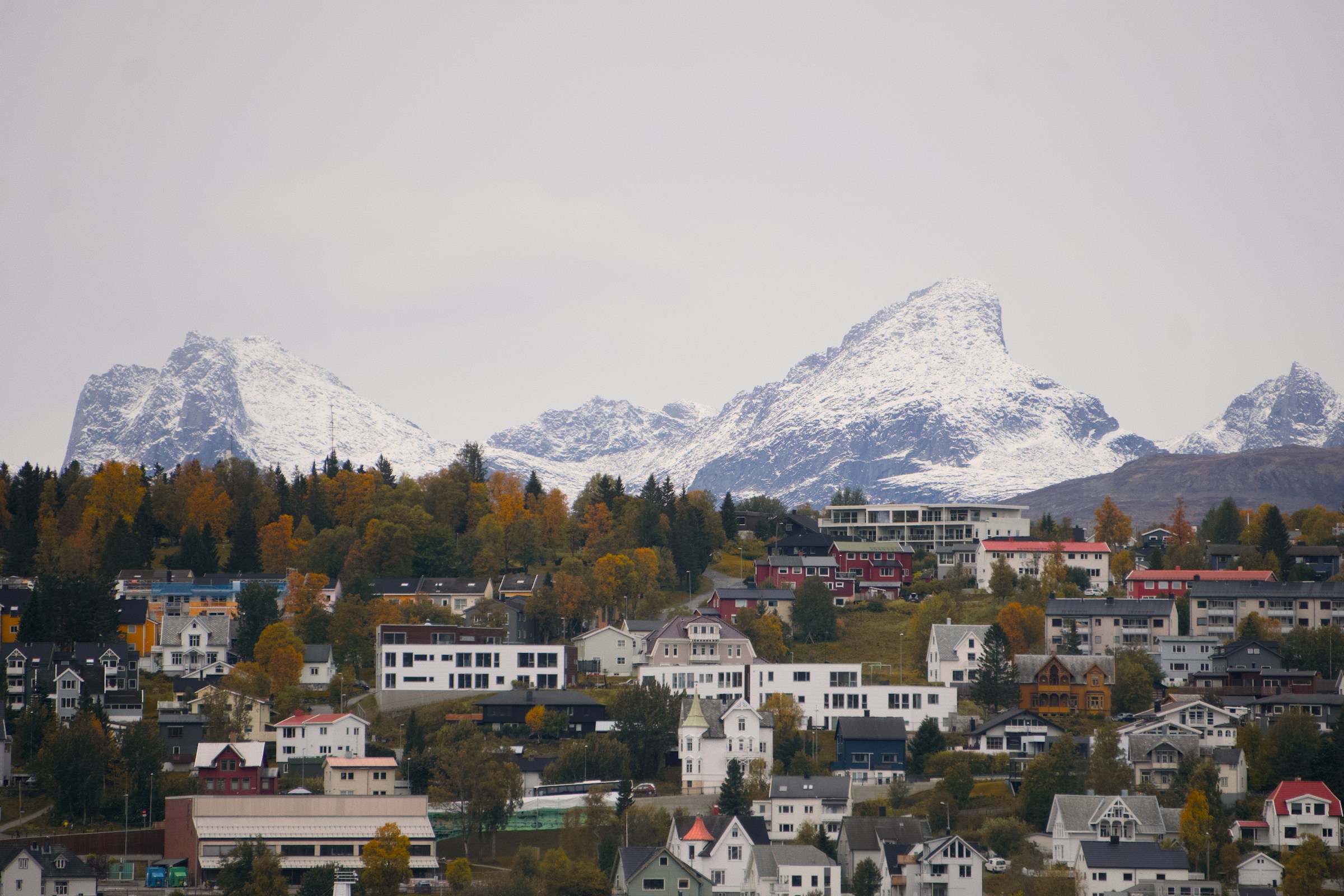 An illustrative photo of a city with mountains in the background.