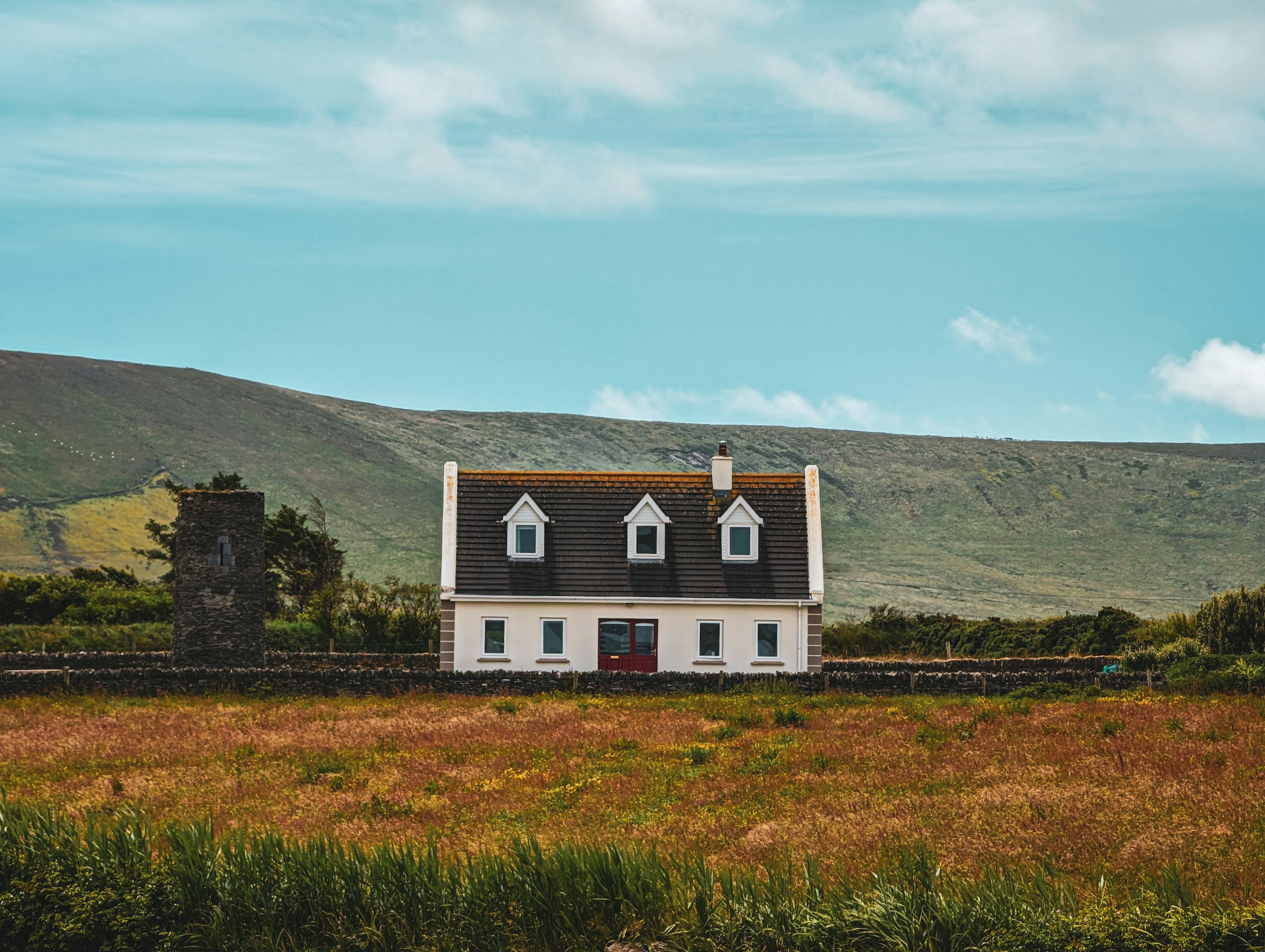 Photo by Unsplash An illustrative photo of a white house on top of green field.