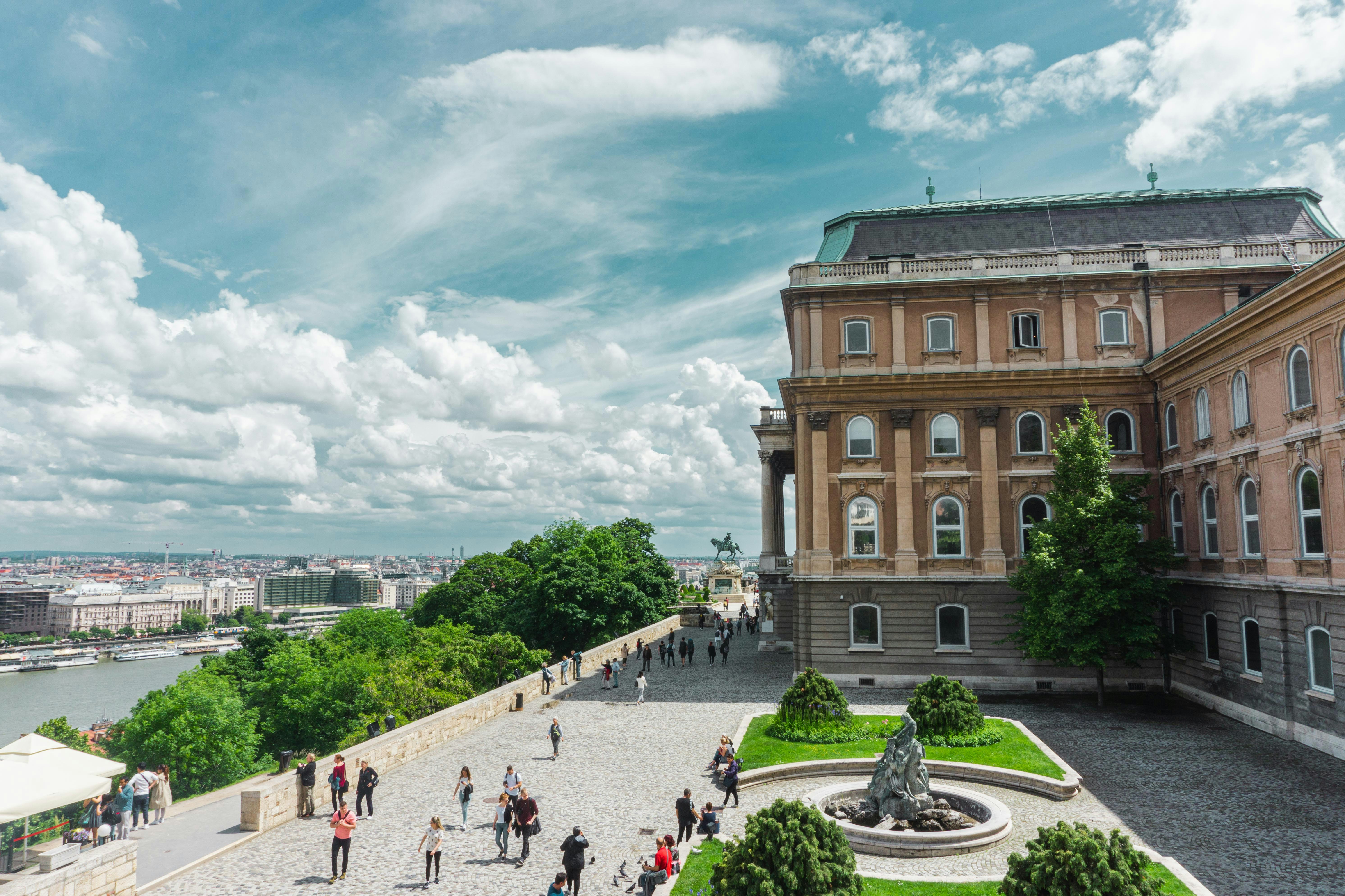 An illustrative photo of people walking in park near brown concrete building