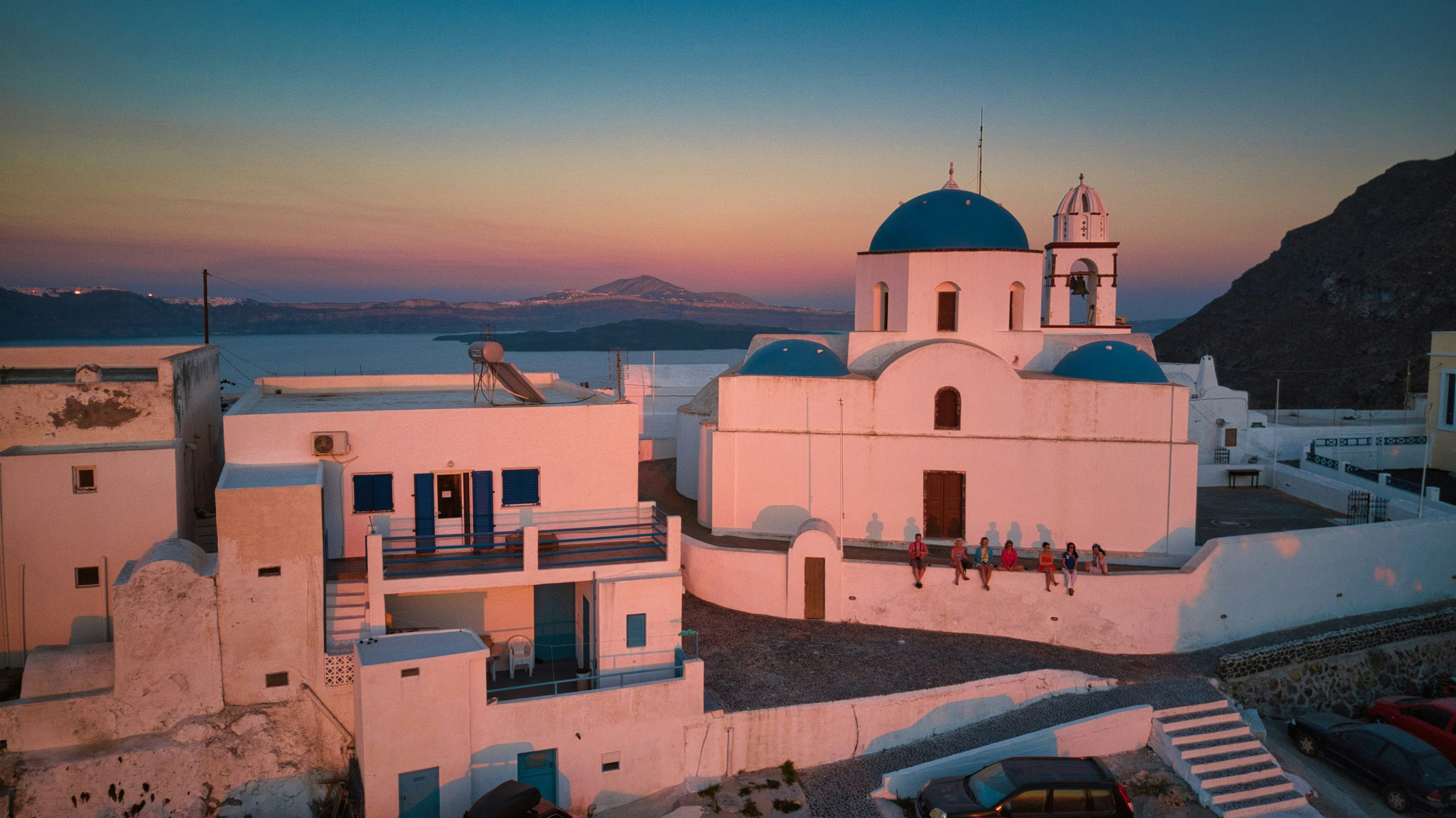 An illustrative photo of white concrete buildings near the sea during sunset.