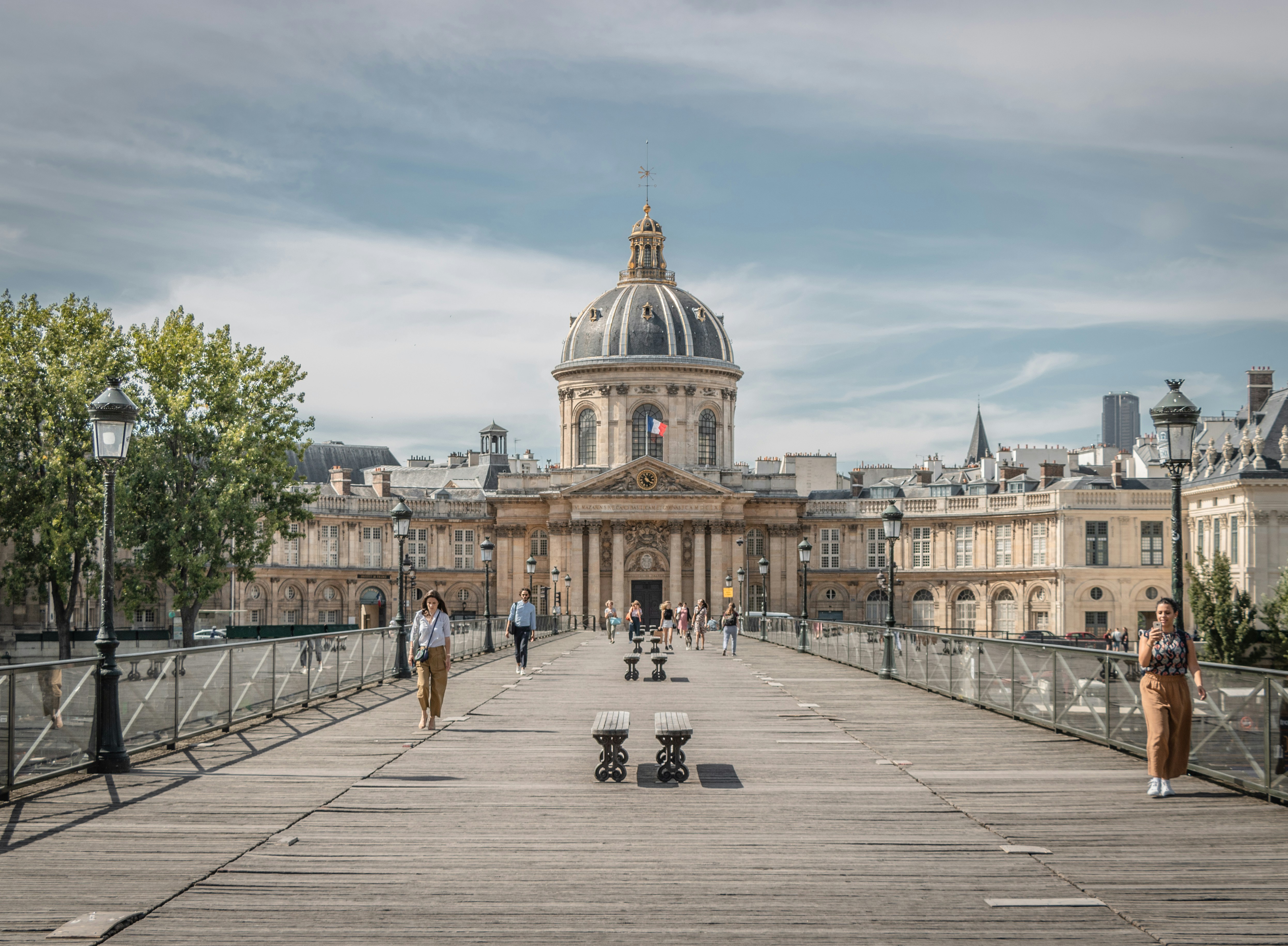 An illustrative photo of people walking on sidewalk near buildings.