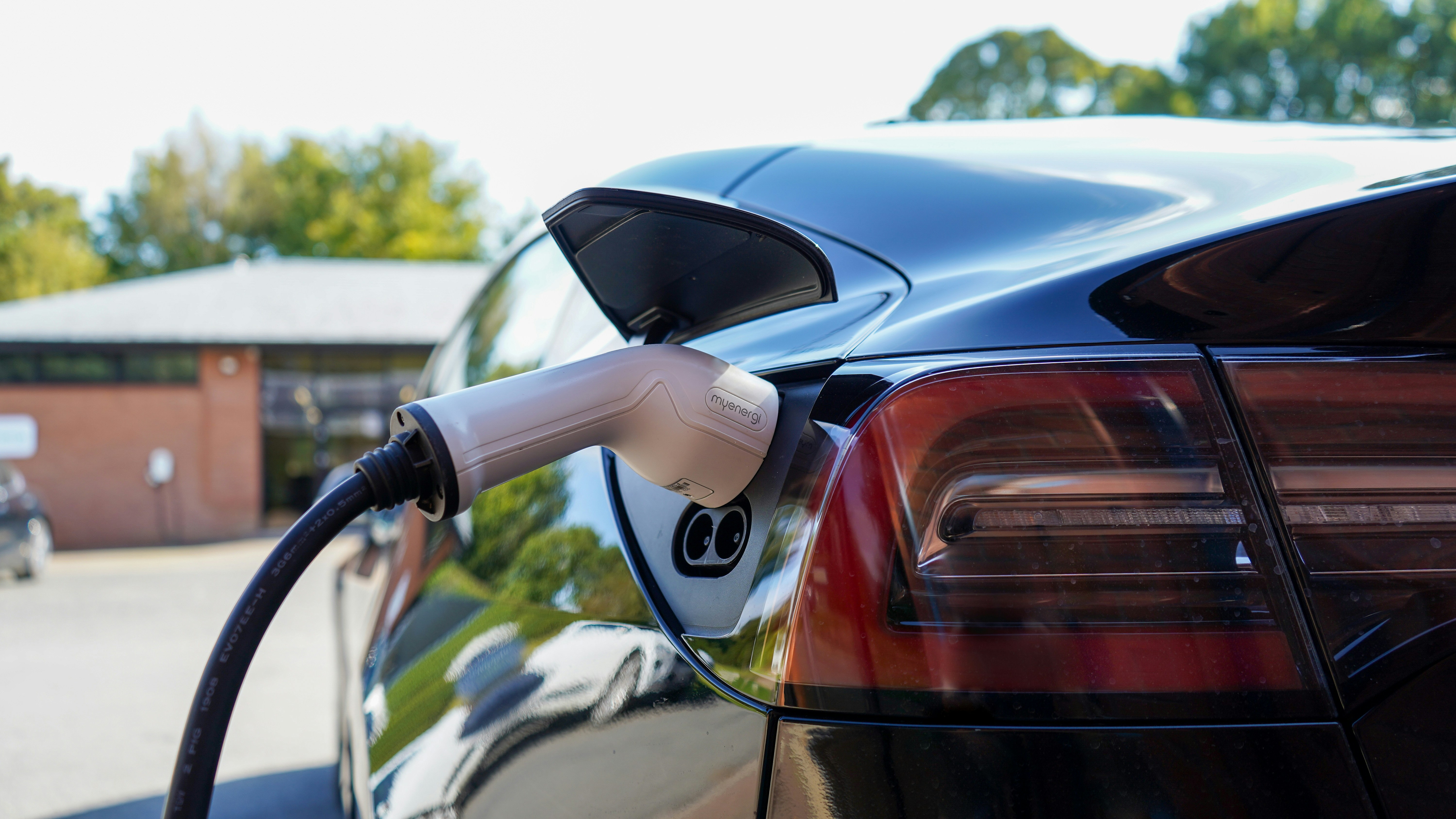 An illustrative photo of a black electric car charging.