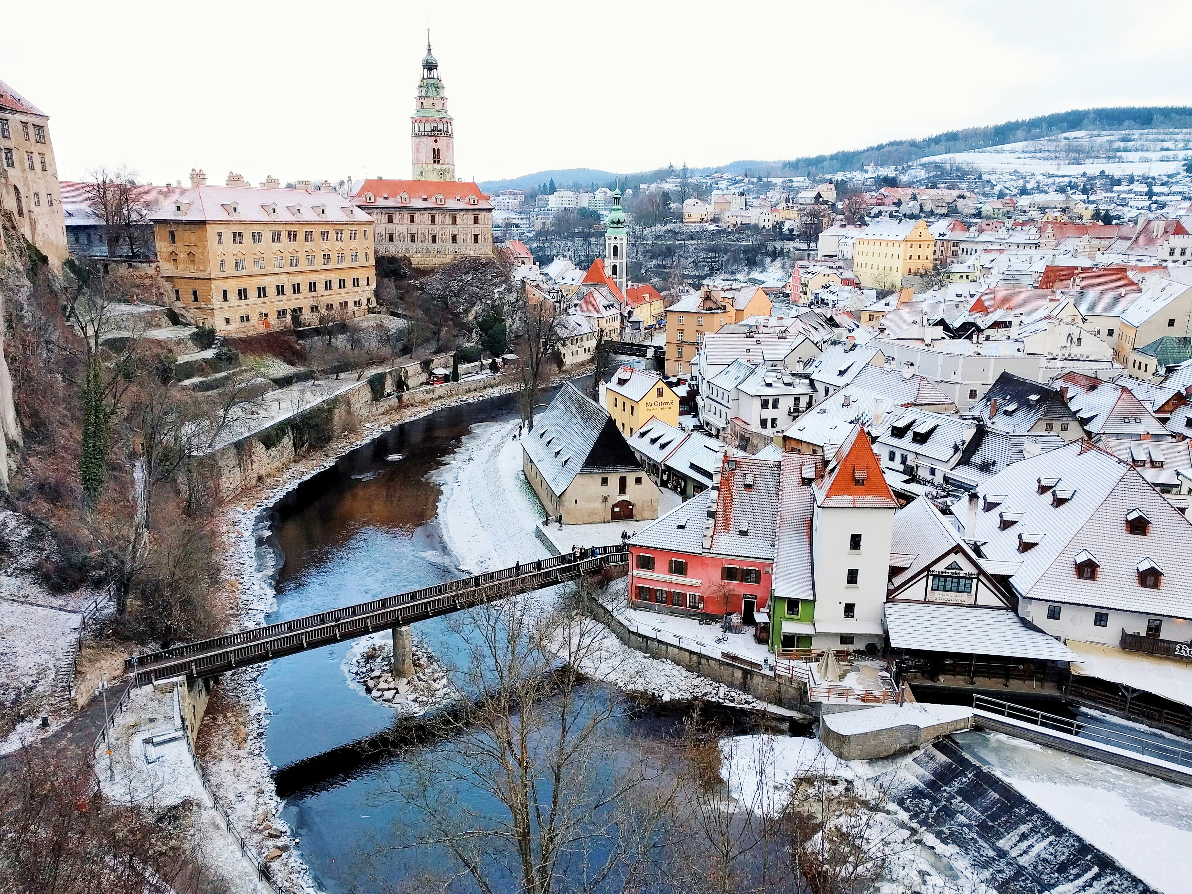 An illustrative photo of snow-covered houses near a river.