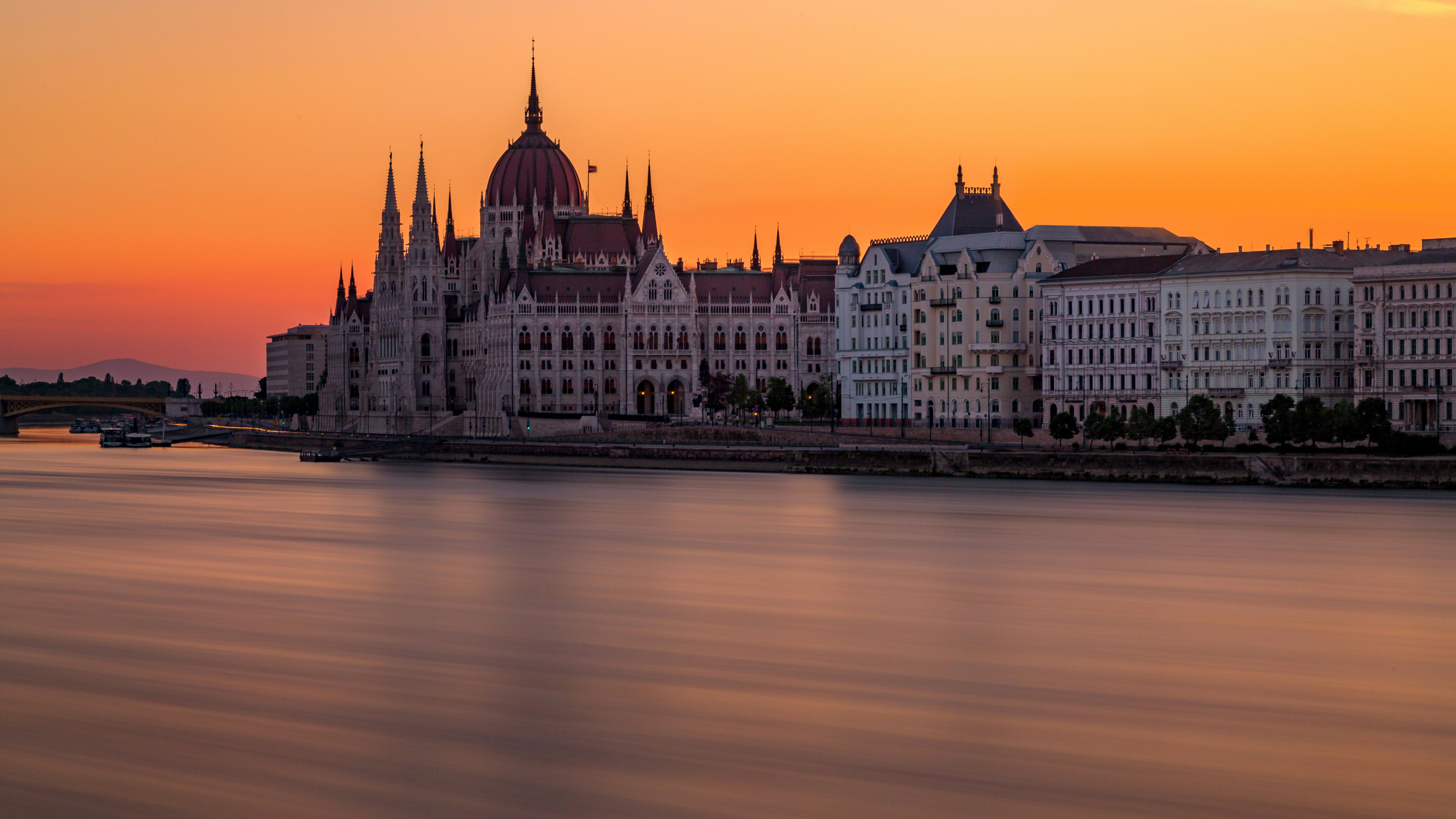 Image by Unsplash An illustrative photo of the Hungarian Parliament building near a river during sunset.