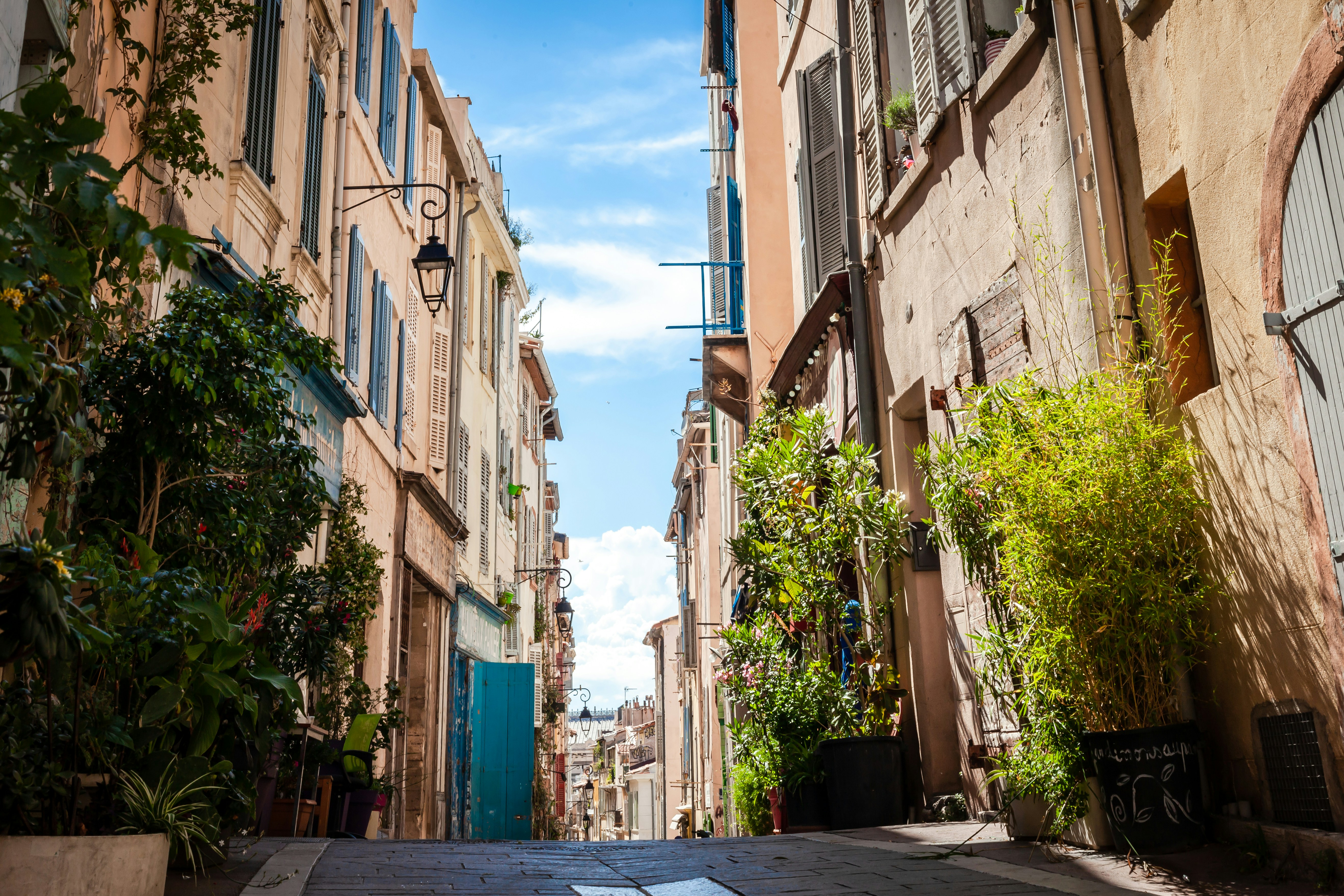 An illustrative photo of cars parked on sidewalk in between buildings.