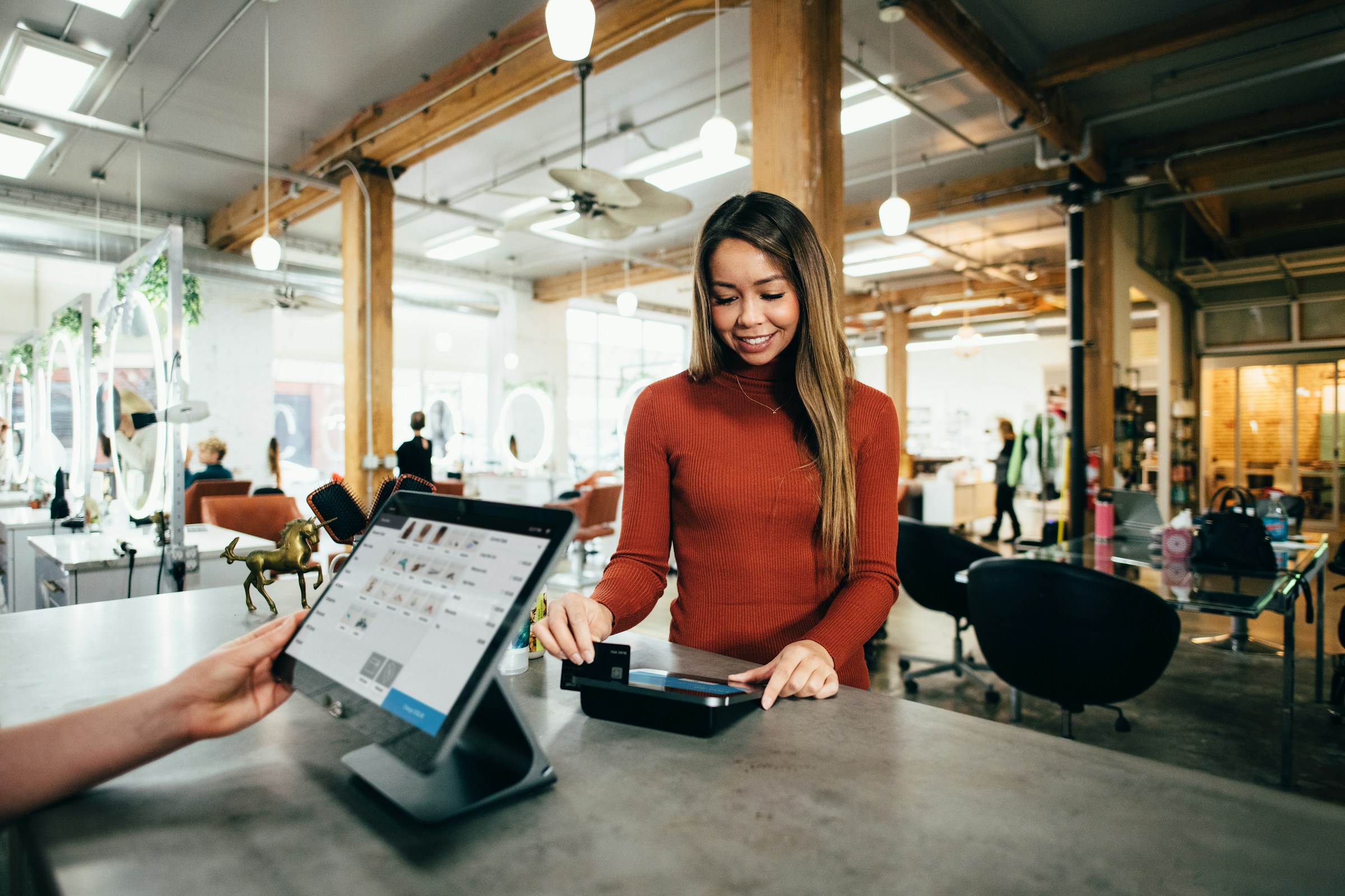 An illustrative photo of a woman standing at a table.