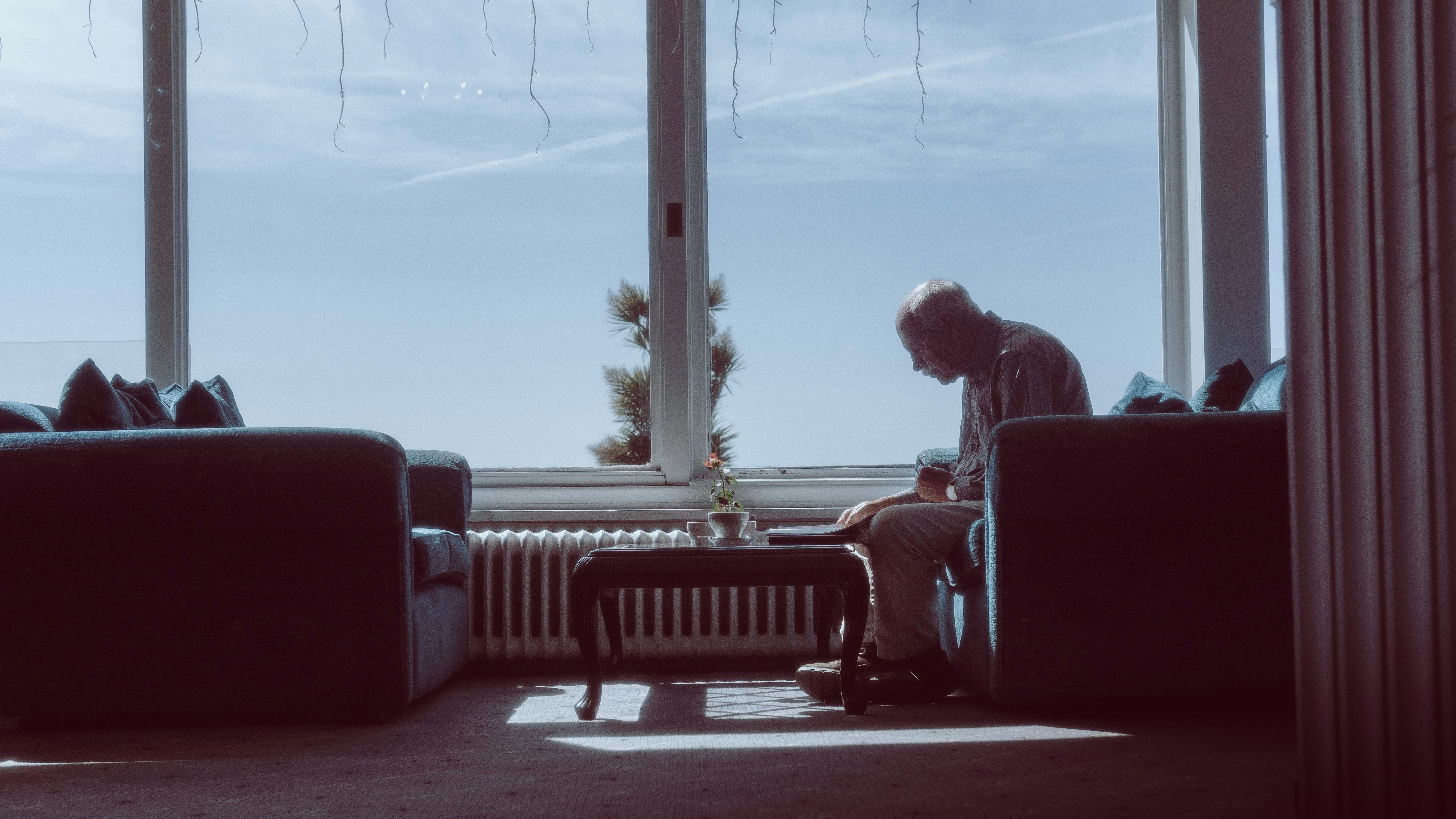 An illustrative photo of a man sitting on a couch.