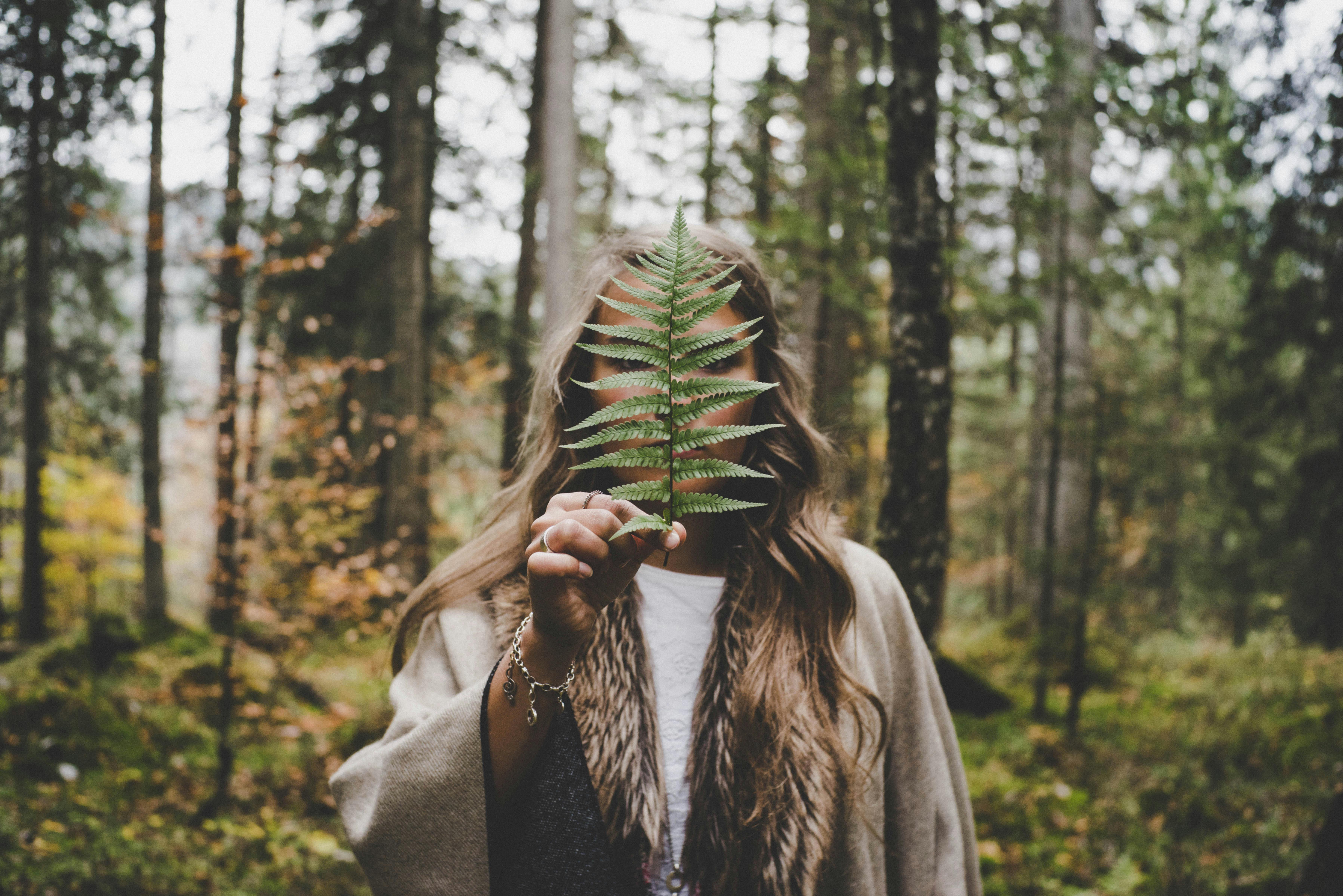 An illustrative photo of a woman standing at woods.