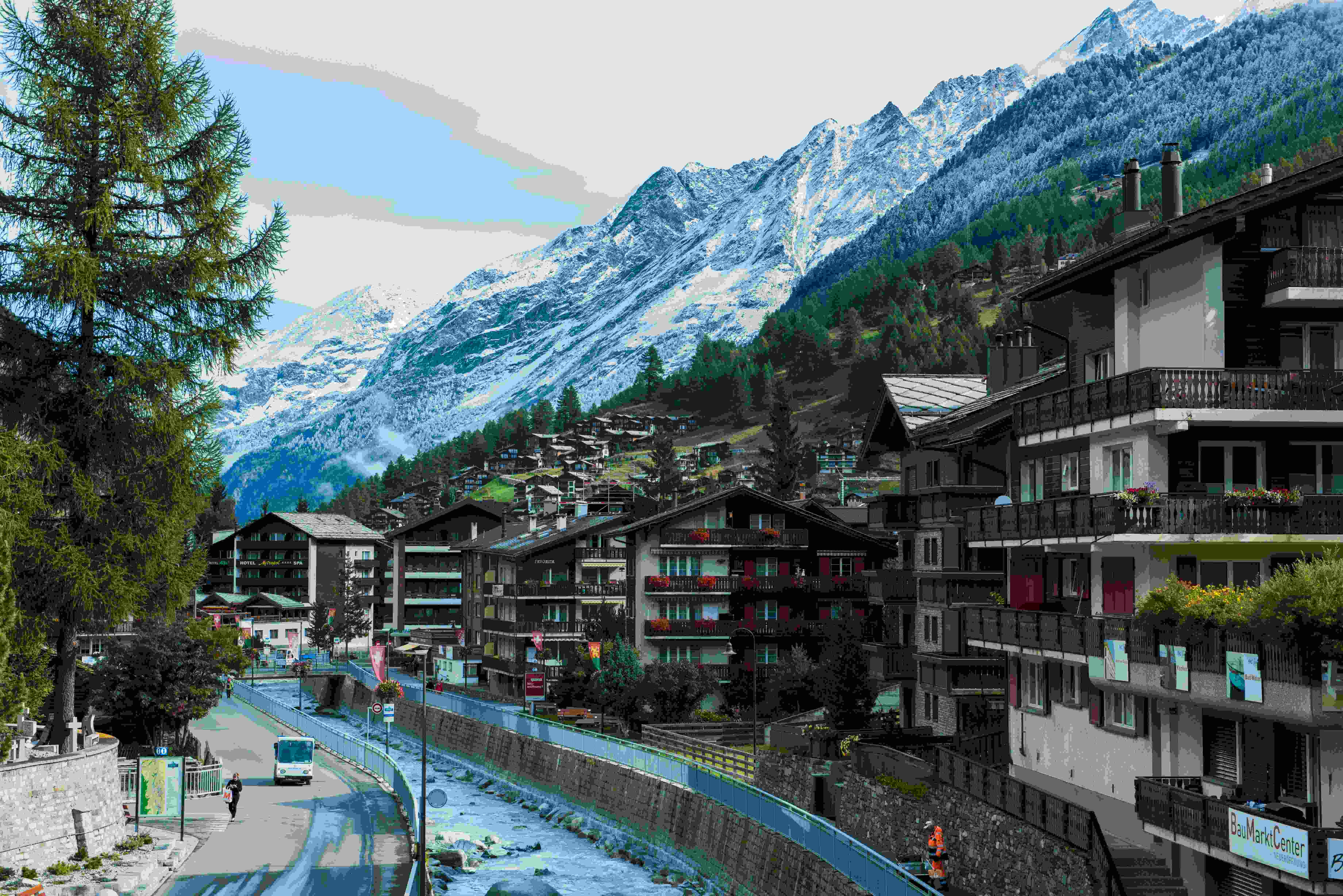 Image by Unsplash An illustrative photo of houses near road and mountain under blue sky.