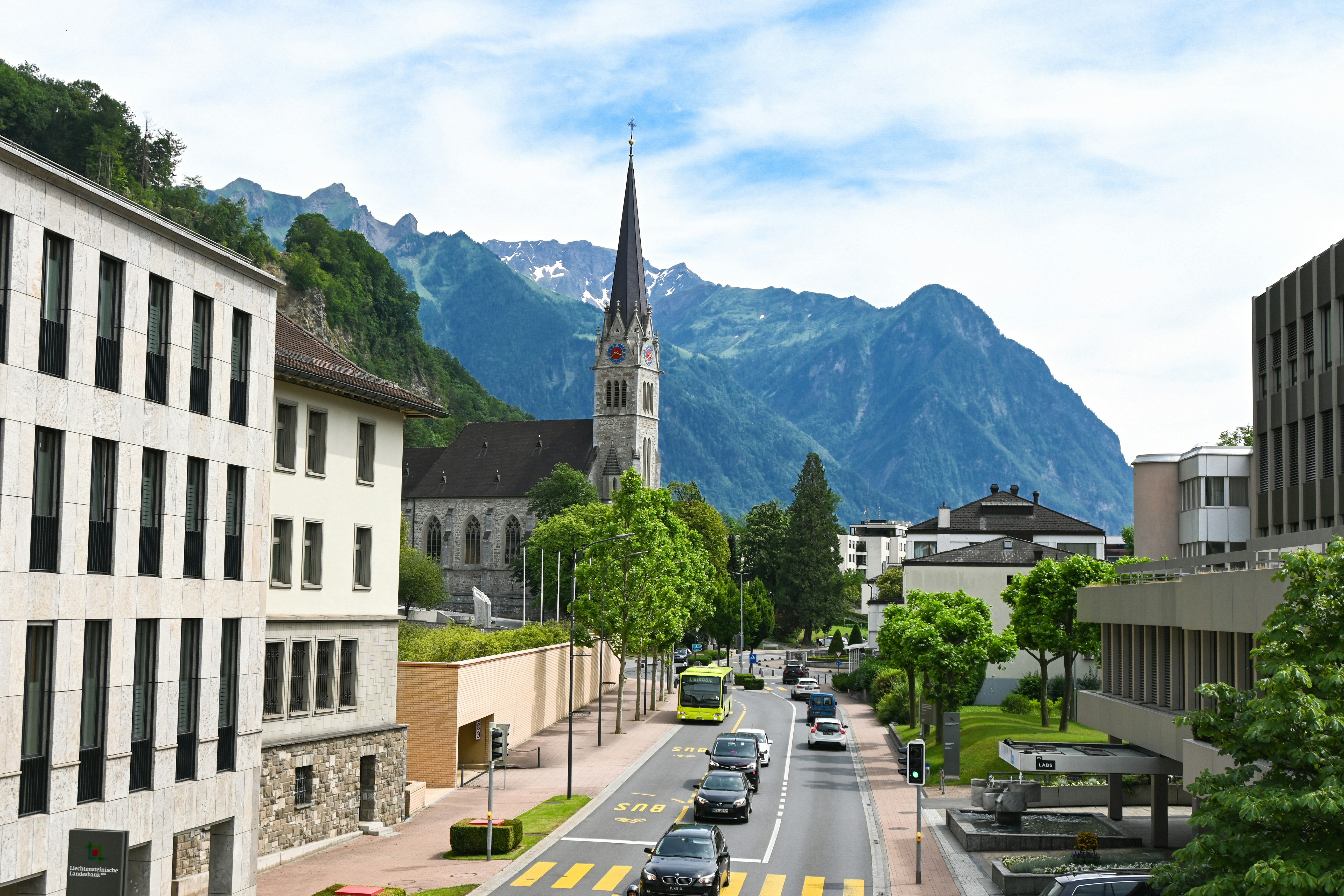 Image by Unsplash An illustrative photo of cars on a road in a town with mountains in the background.