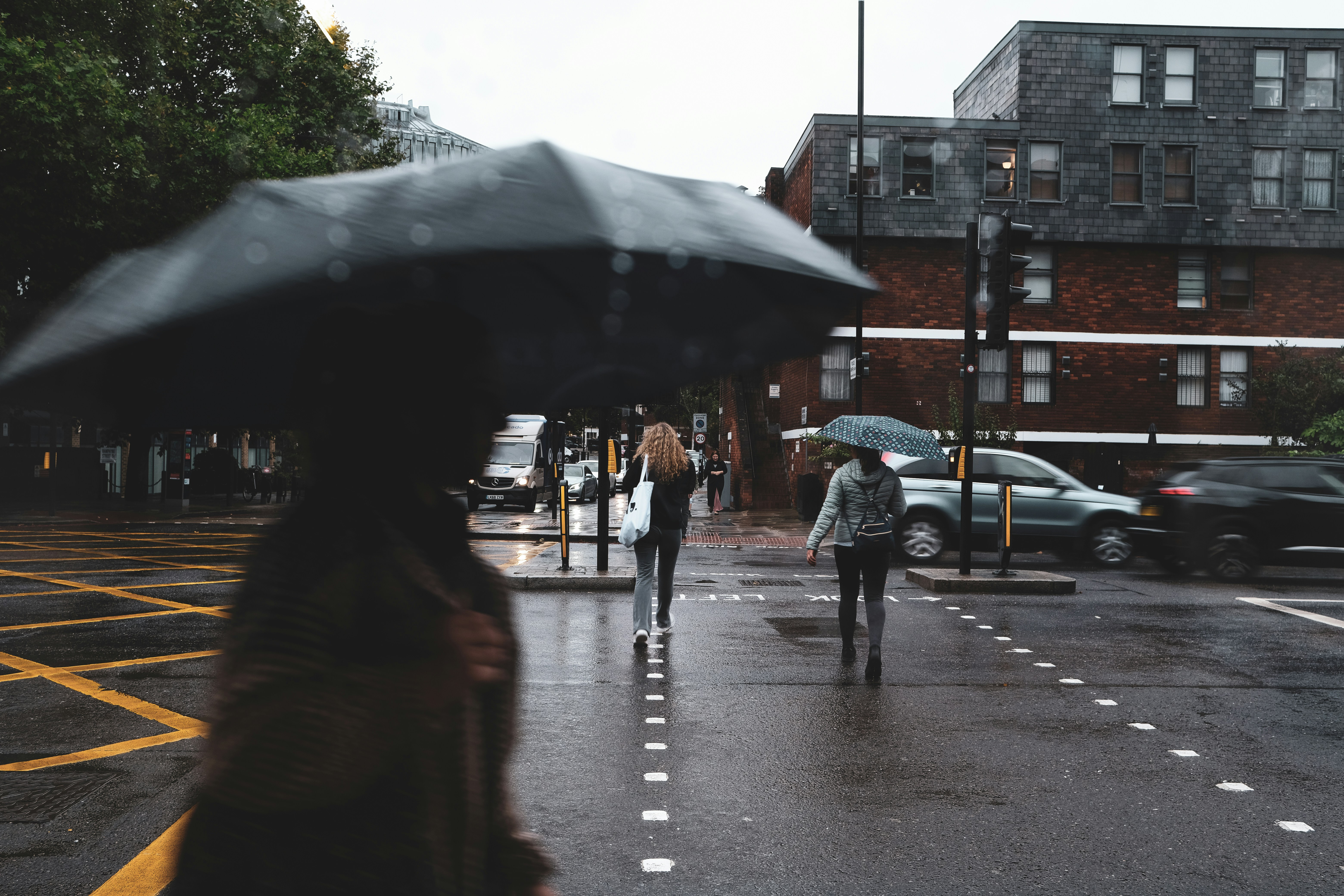 An illustrative photo of a woman walking down a street holding an umbrella.