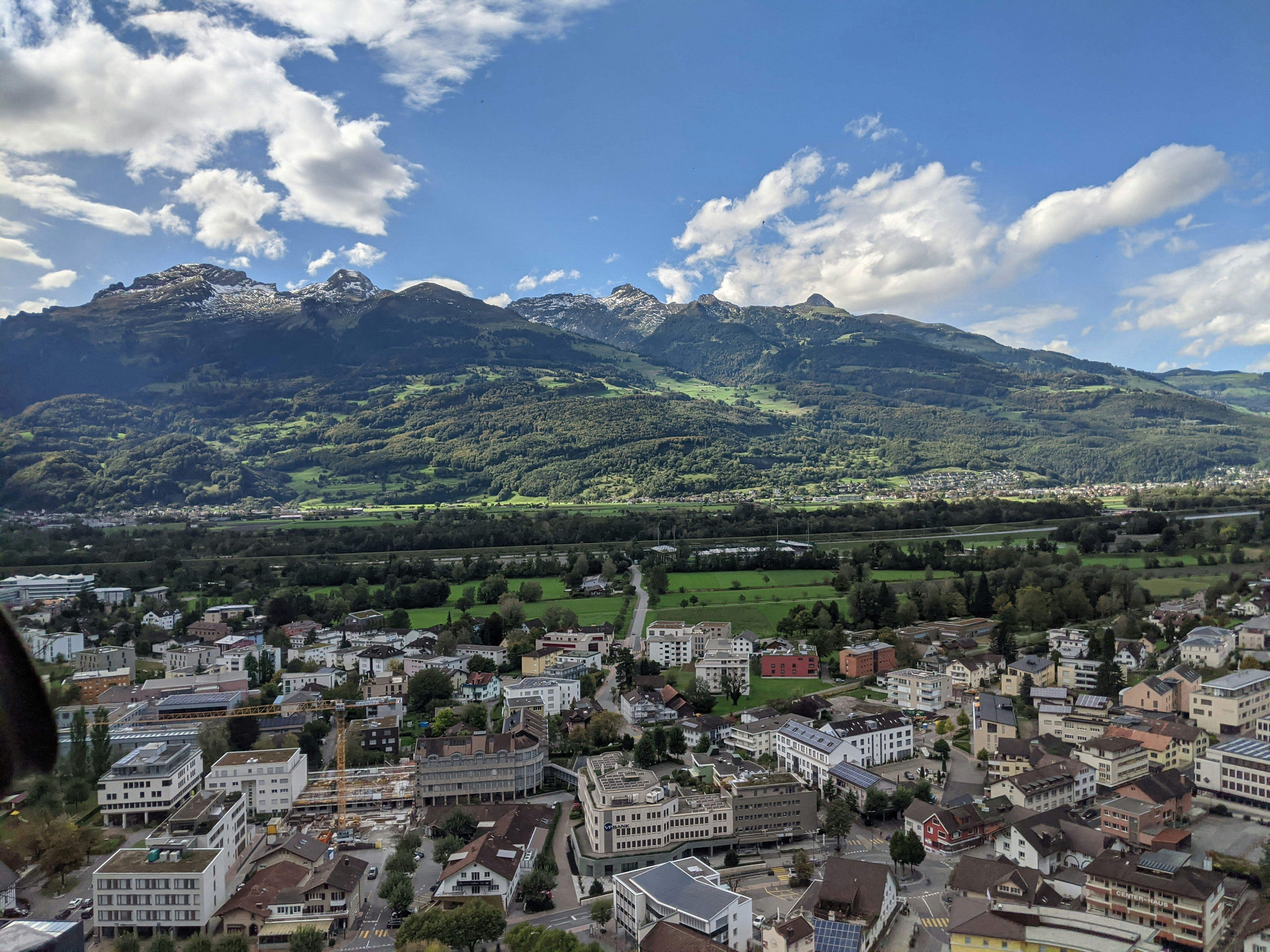 Image by Unsplash An illustrative photo of city buildings and green mountains.