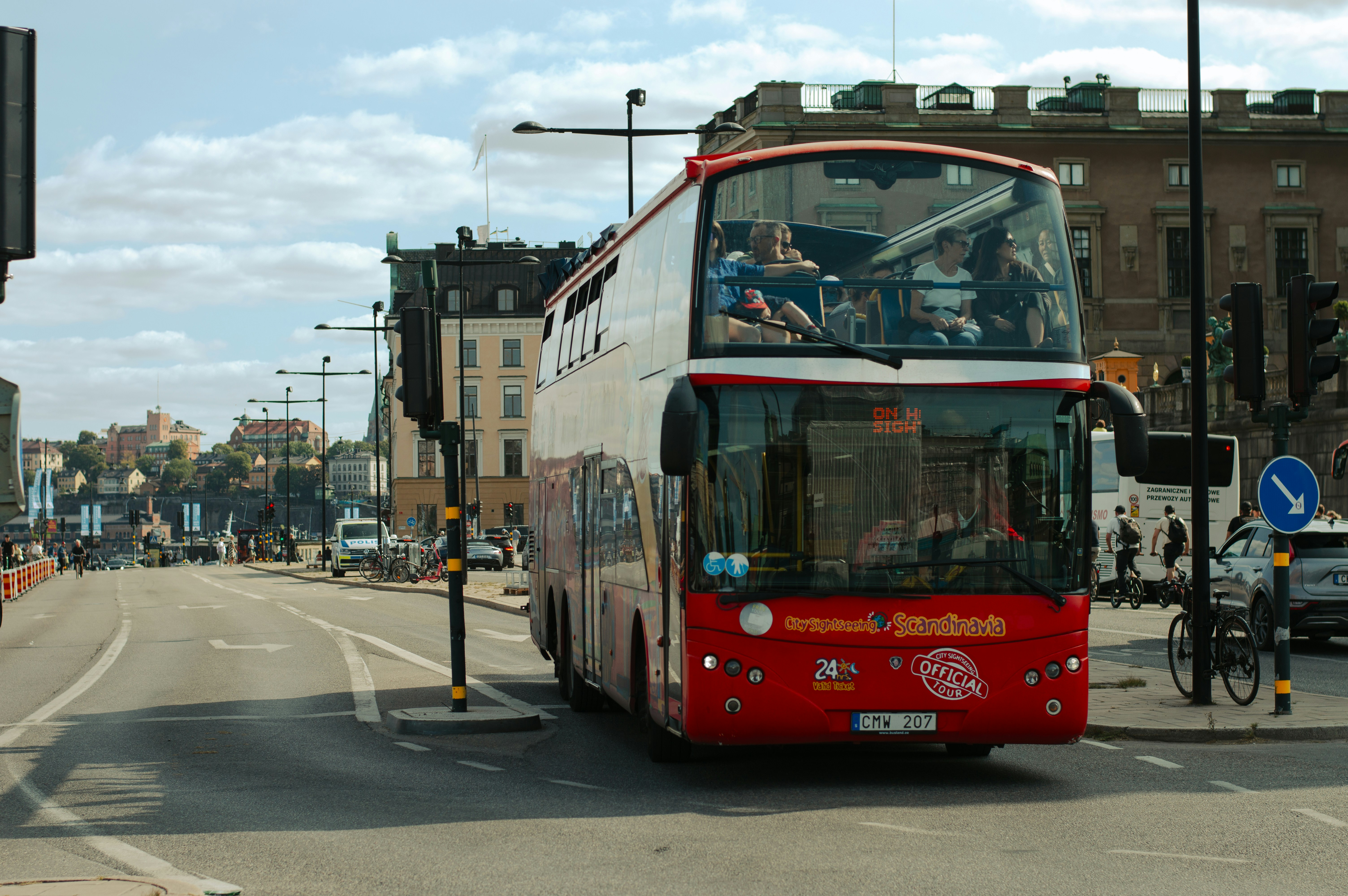 An illustrative photo of a red and white double decker bus driving down a street.