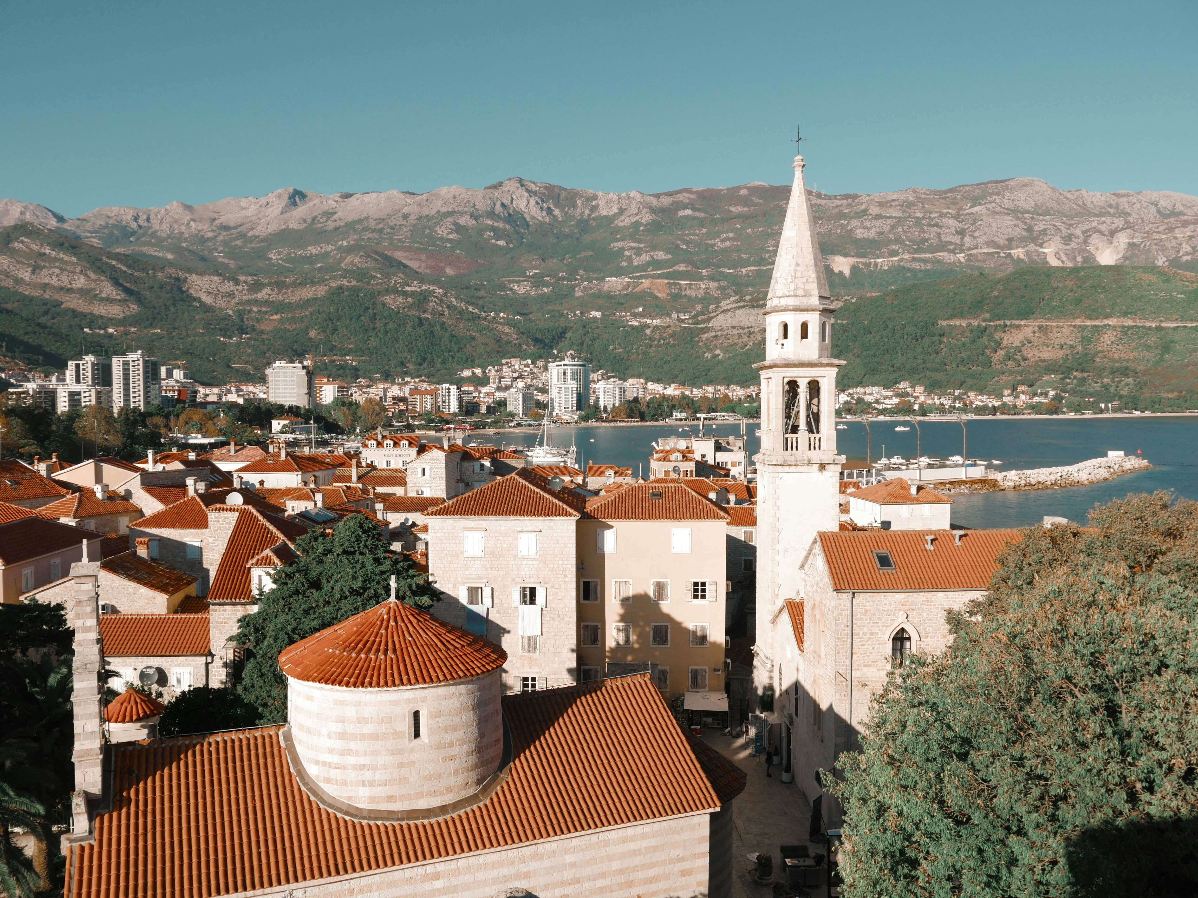 Image by Unsplash An illustrative photo of buildings near a lake and mountains.