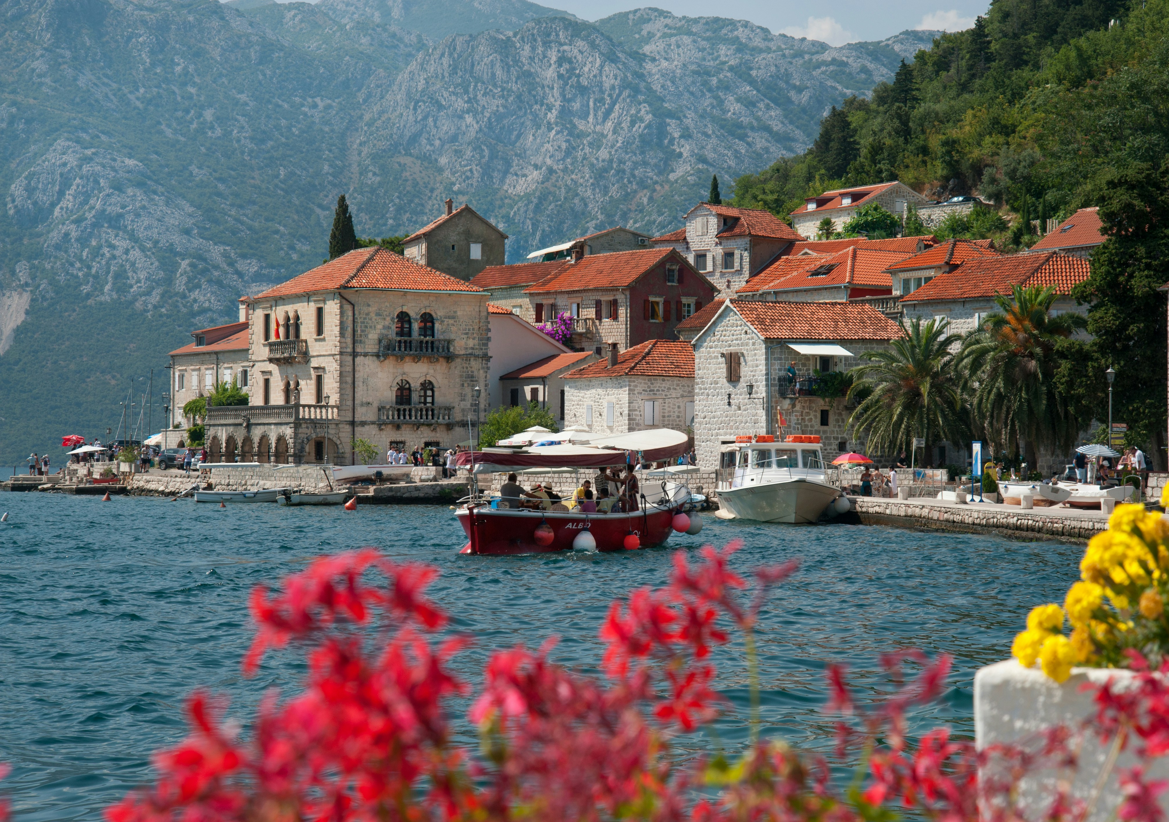 An illustrative photo of a boat floating in a body of water next to a town.