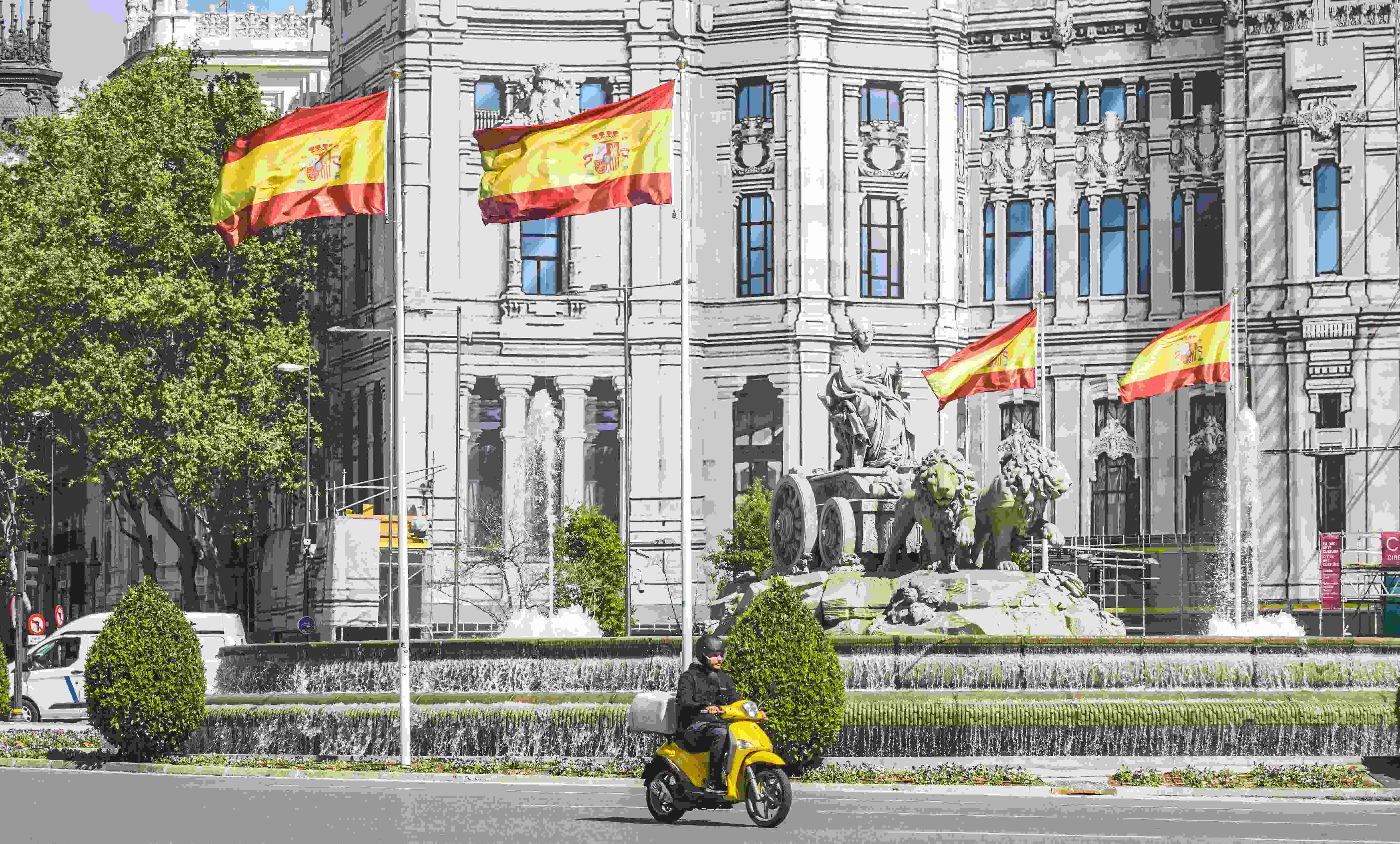 Image by Unsplash An illustrativephoto of a man riding a motorcycle near a white building.