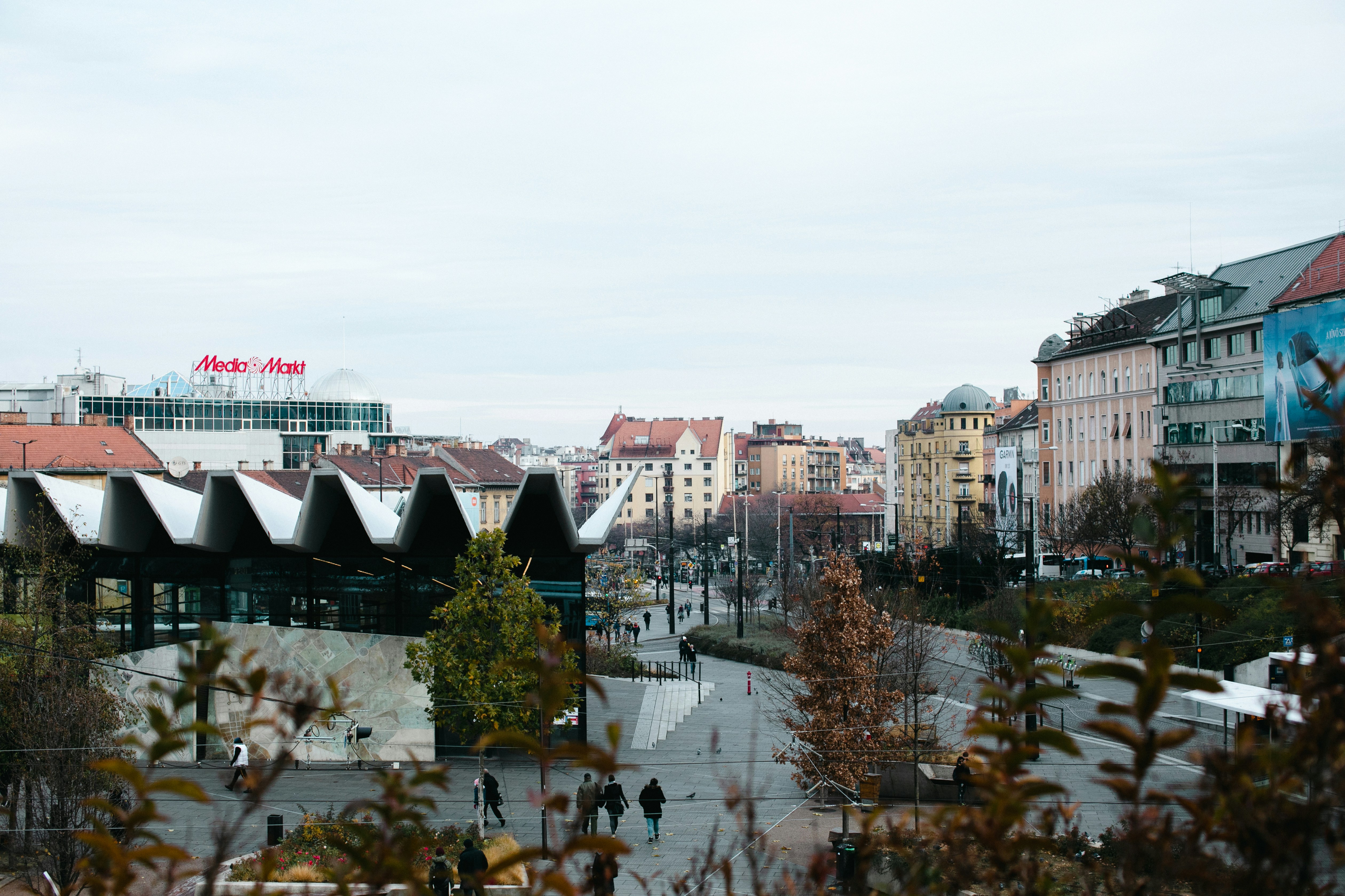 An illustrative photo of a group of people walking down a street next to tall buildings.
