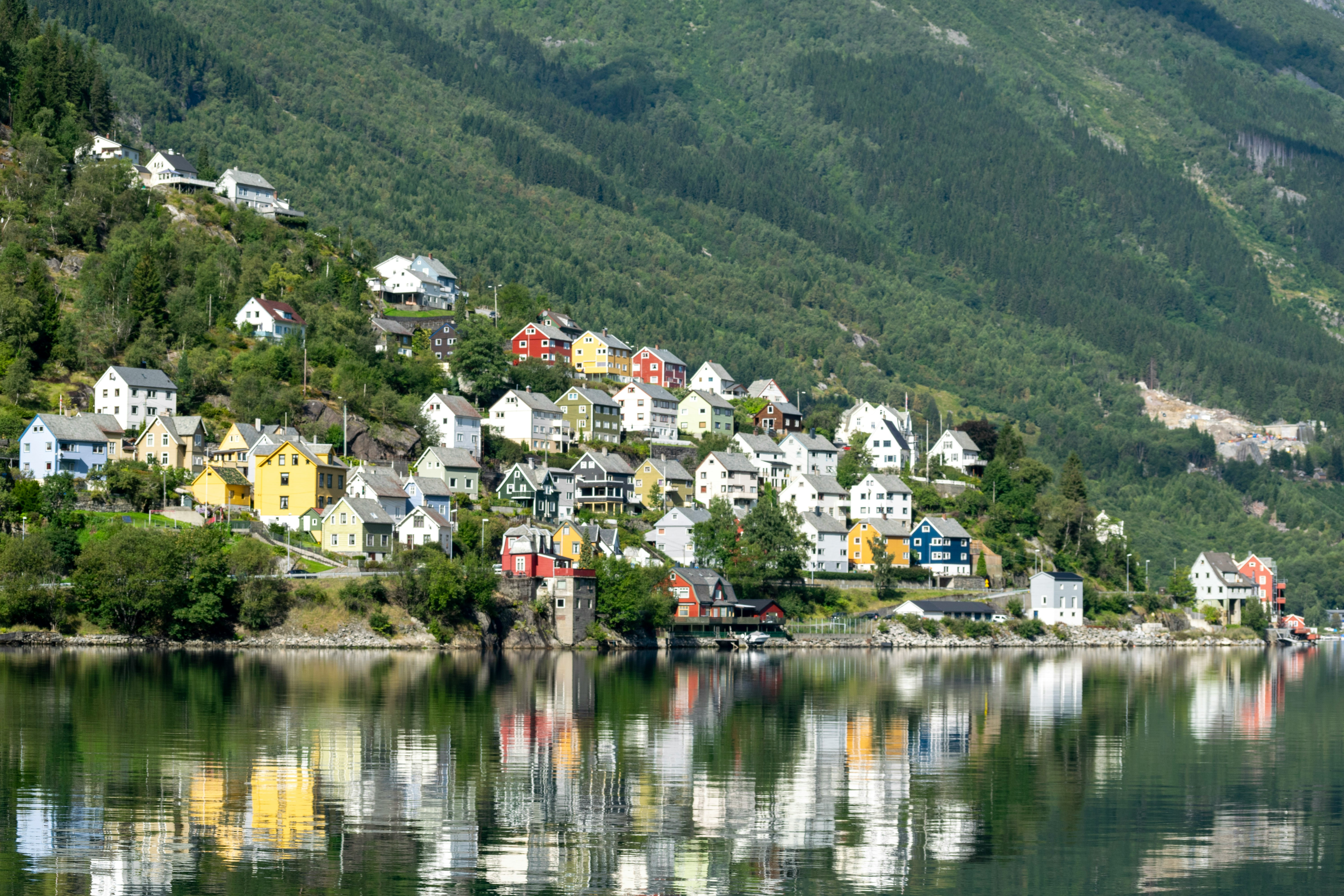 An illustrative photo of a small town on a hill with a lake in front of it.