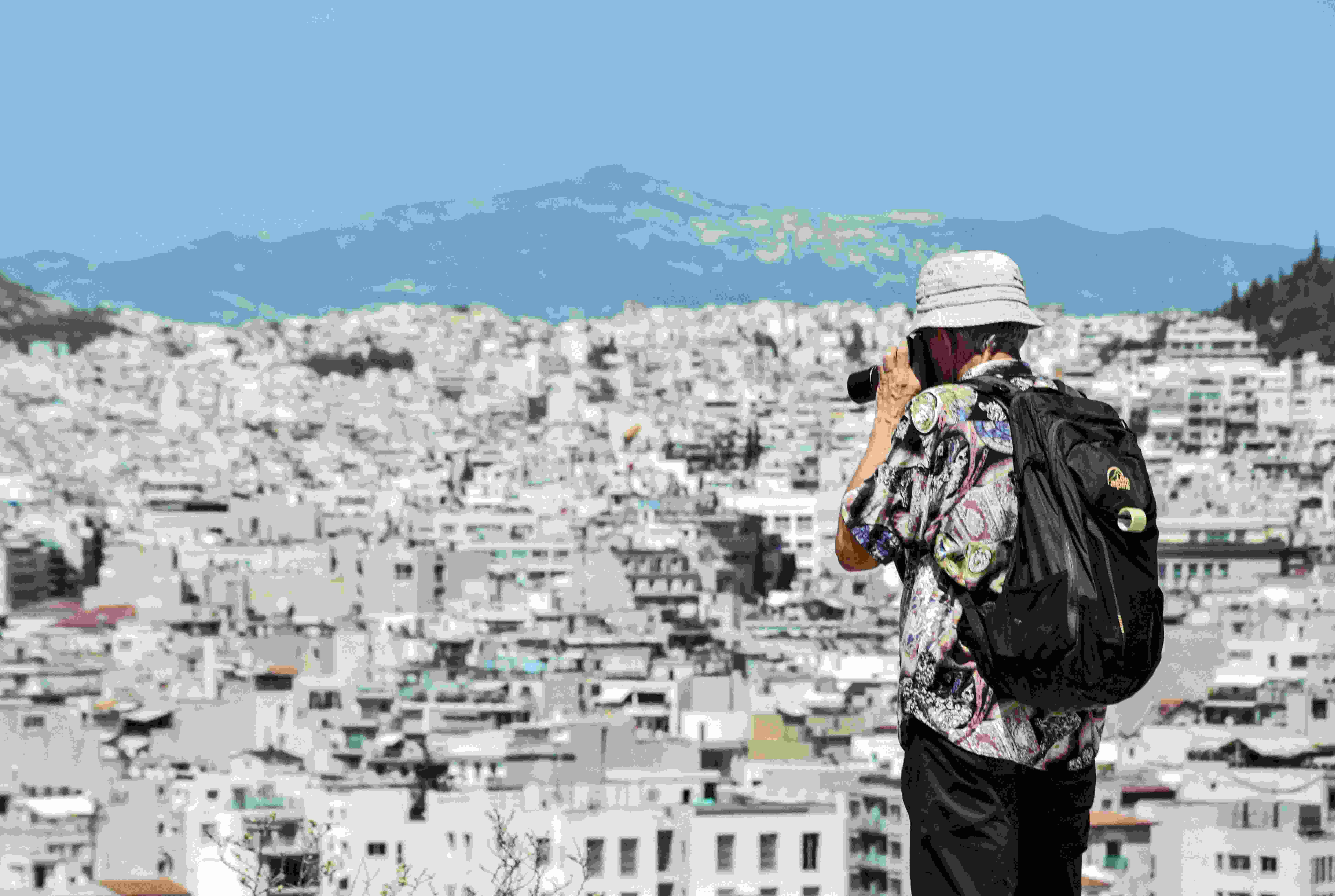Image by Unsplash An illustrative photo of a man standing on top of a hill taking a picture.