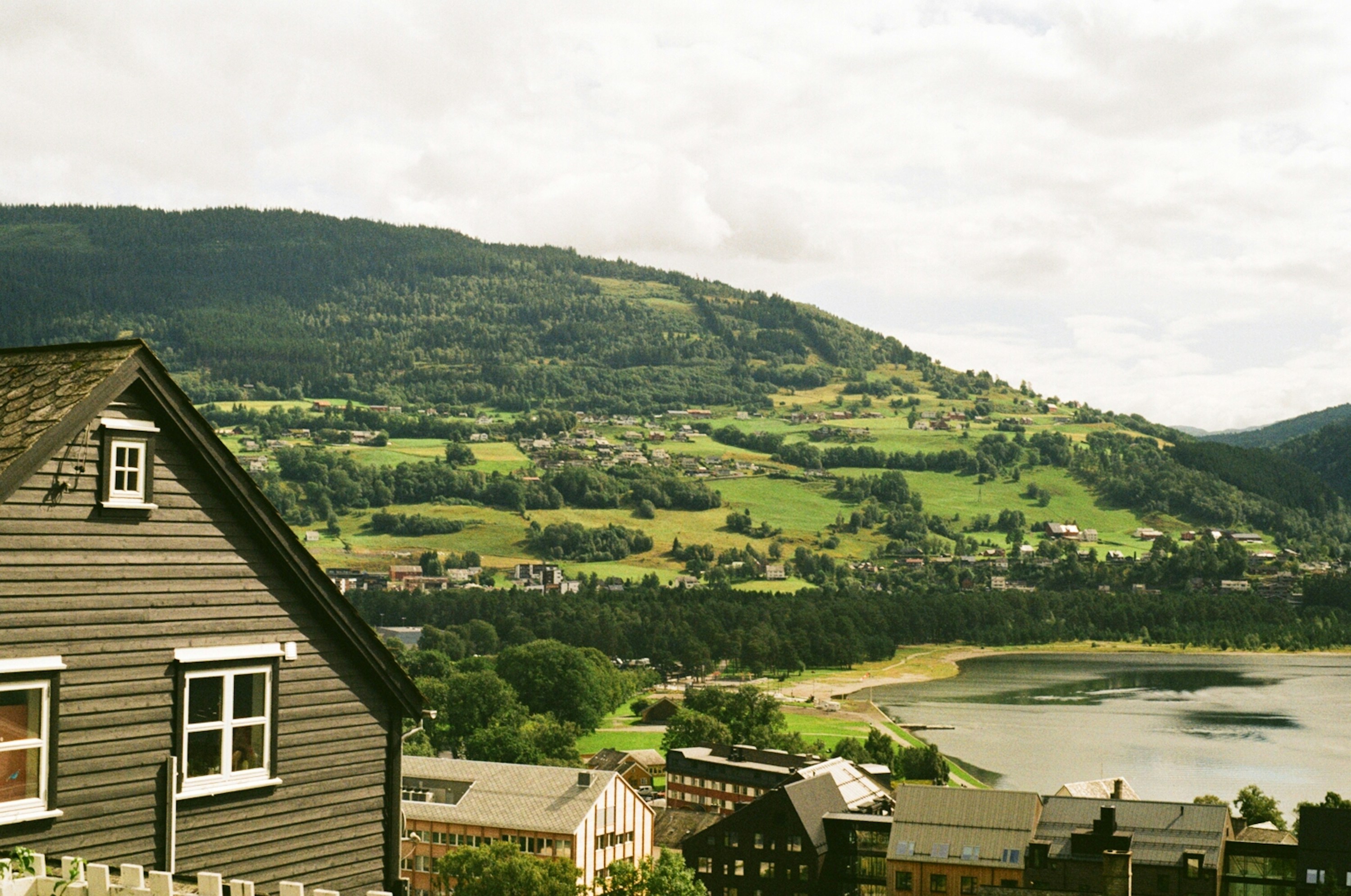 An illustrative photo of a view of a village and a lake from a hill.