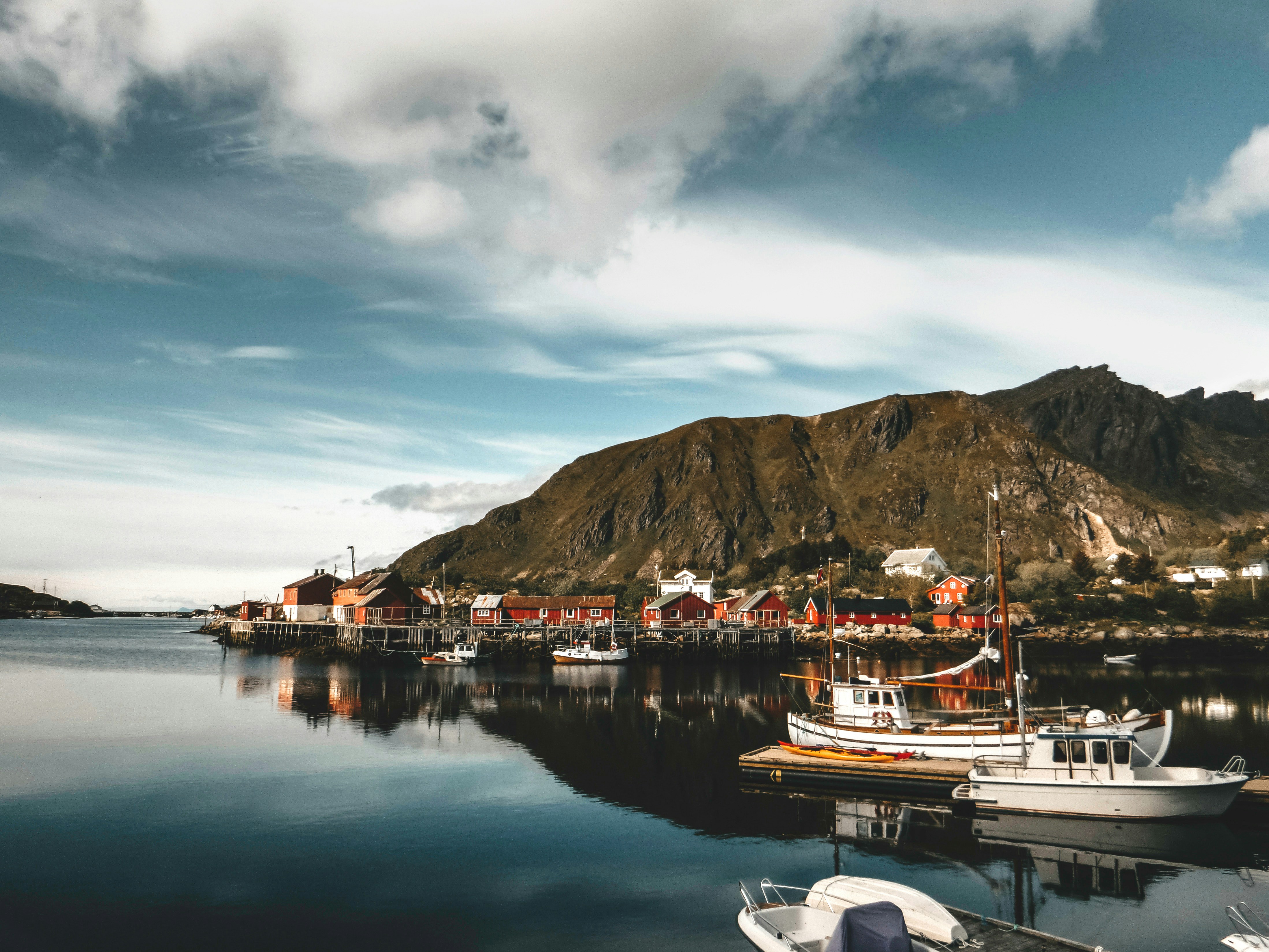 Photo by Unsplash An illustrative photo of a house near a dock and a mountain.