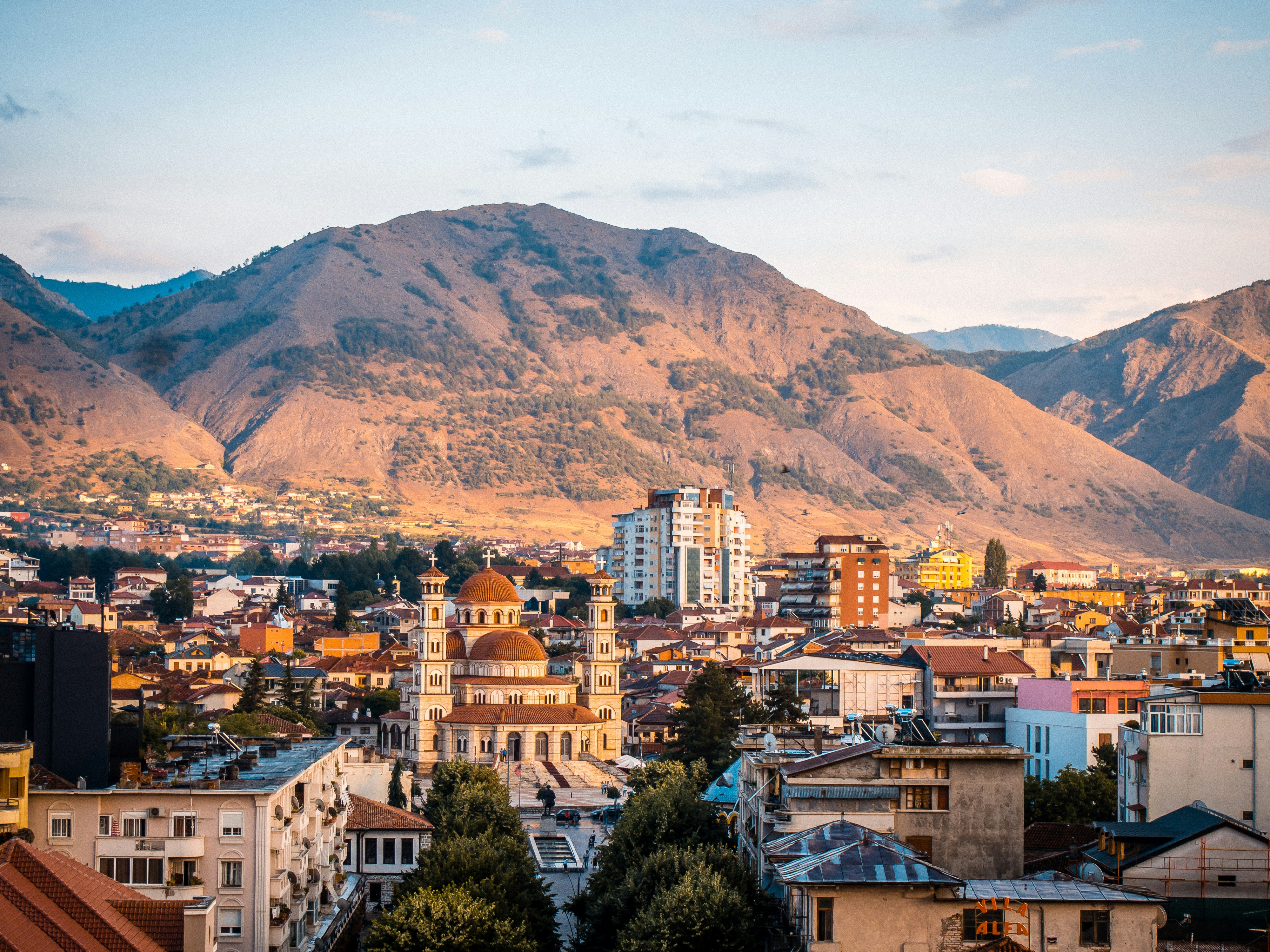 An illustrative photo of a city with mountains in the background.