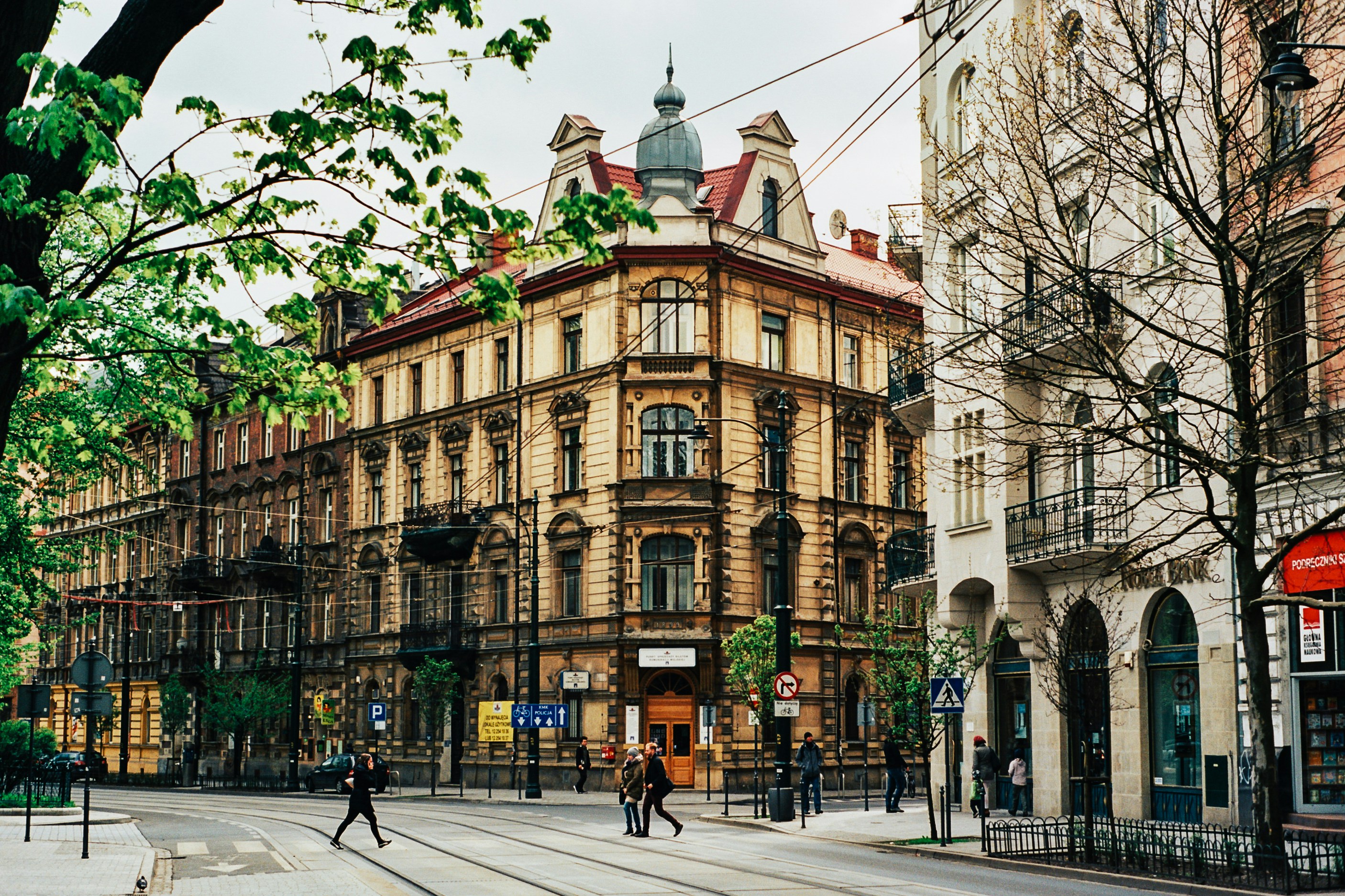Photo by Unsplash An illustrative photo of people walking on a street near beige buildings.