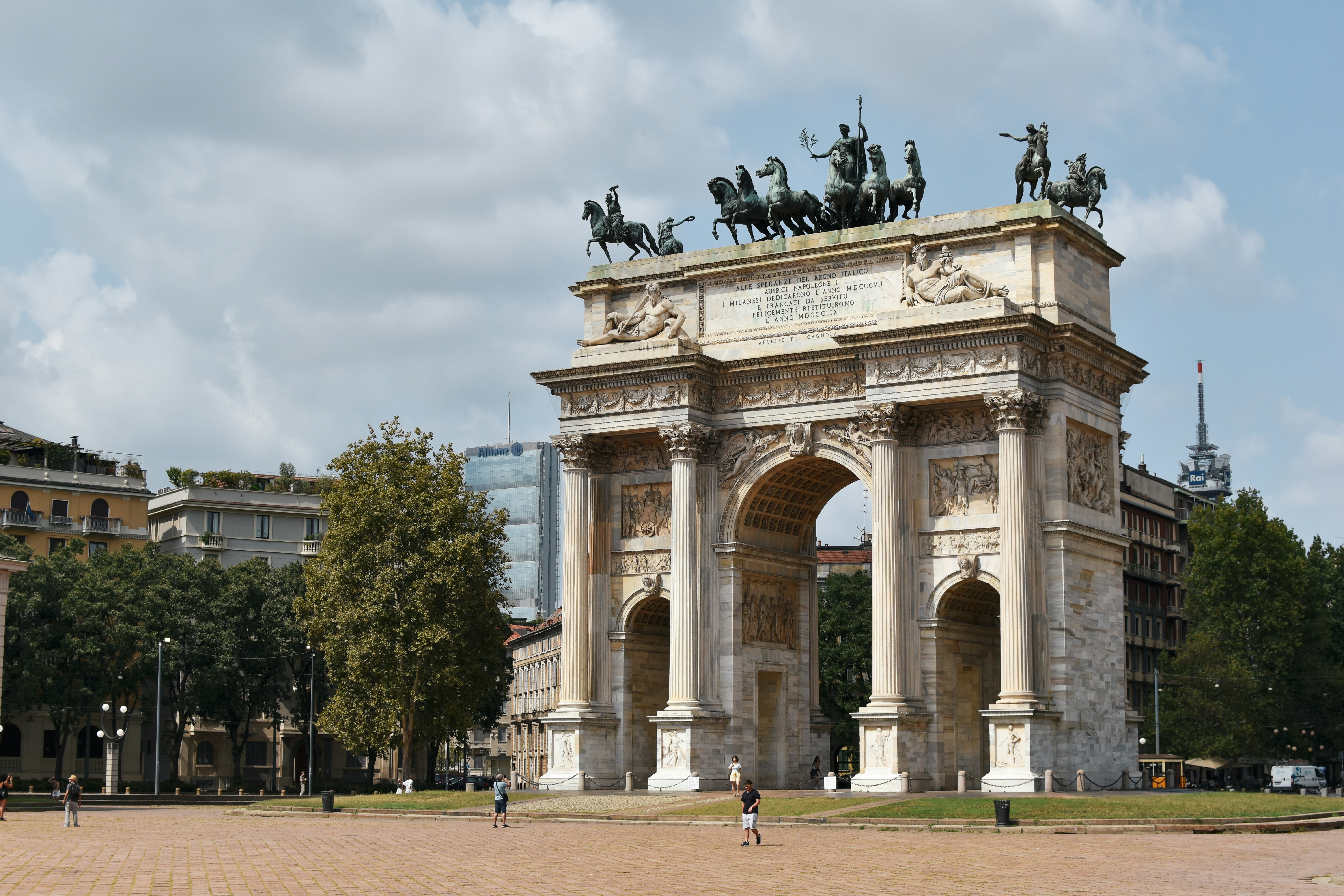 An illustrative photo of a stone arch with statues on top of it.