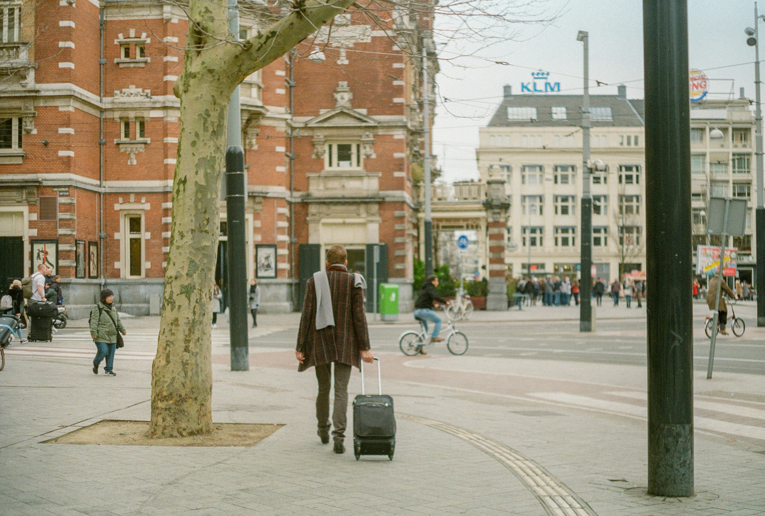 Photo by Unsplash An illustrative photo of a woman walking on a street while carrying a suitcase.
