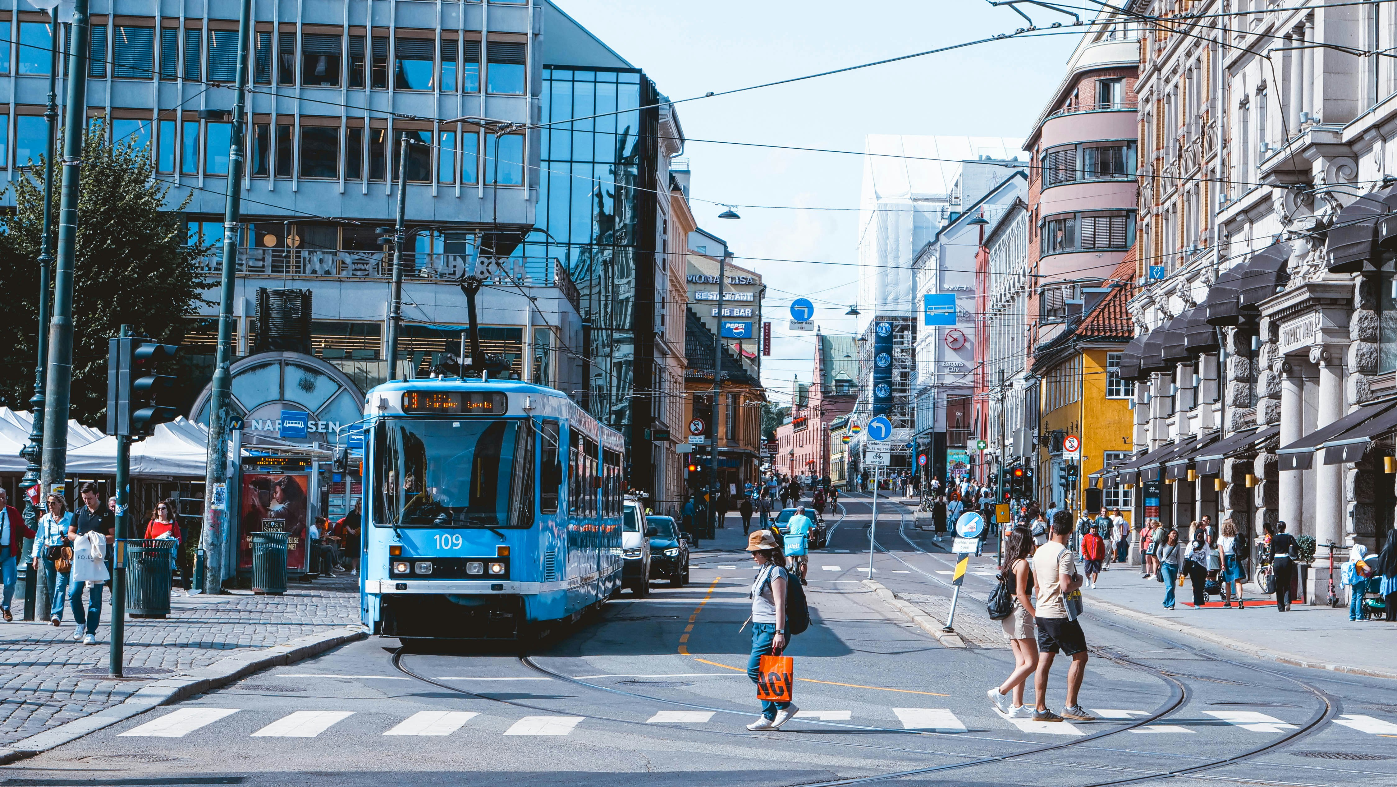 Photo by Unsplash An illustrative photo of a blue bus driving down a street next to tall buildings.