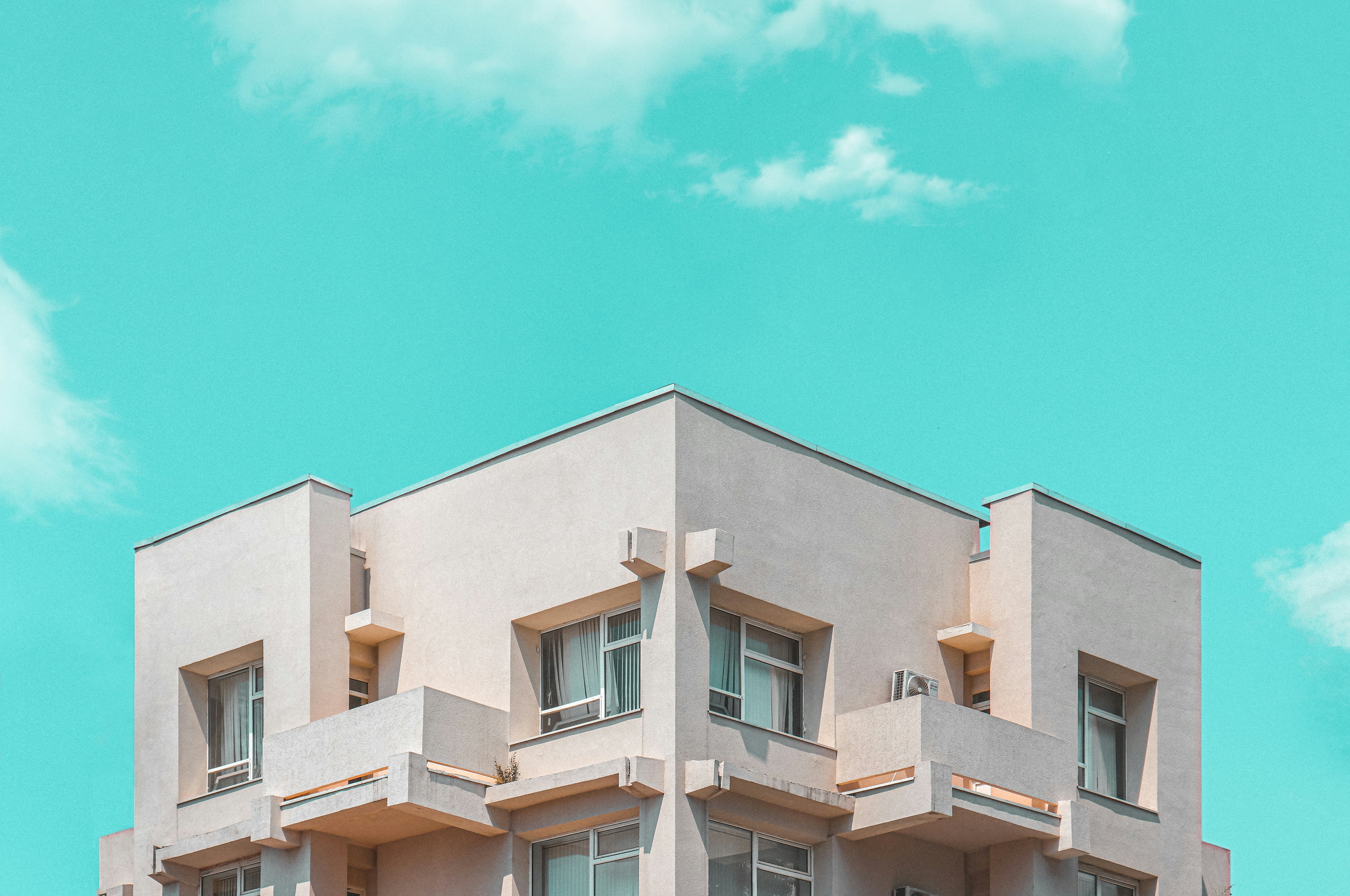 Photo by Unsplash An illustrative photo of a beige concrete building under blue sky.