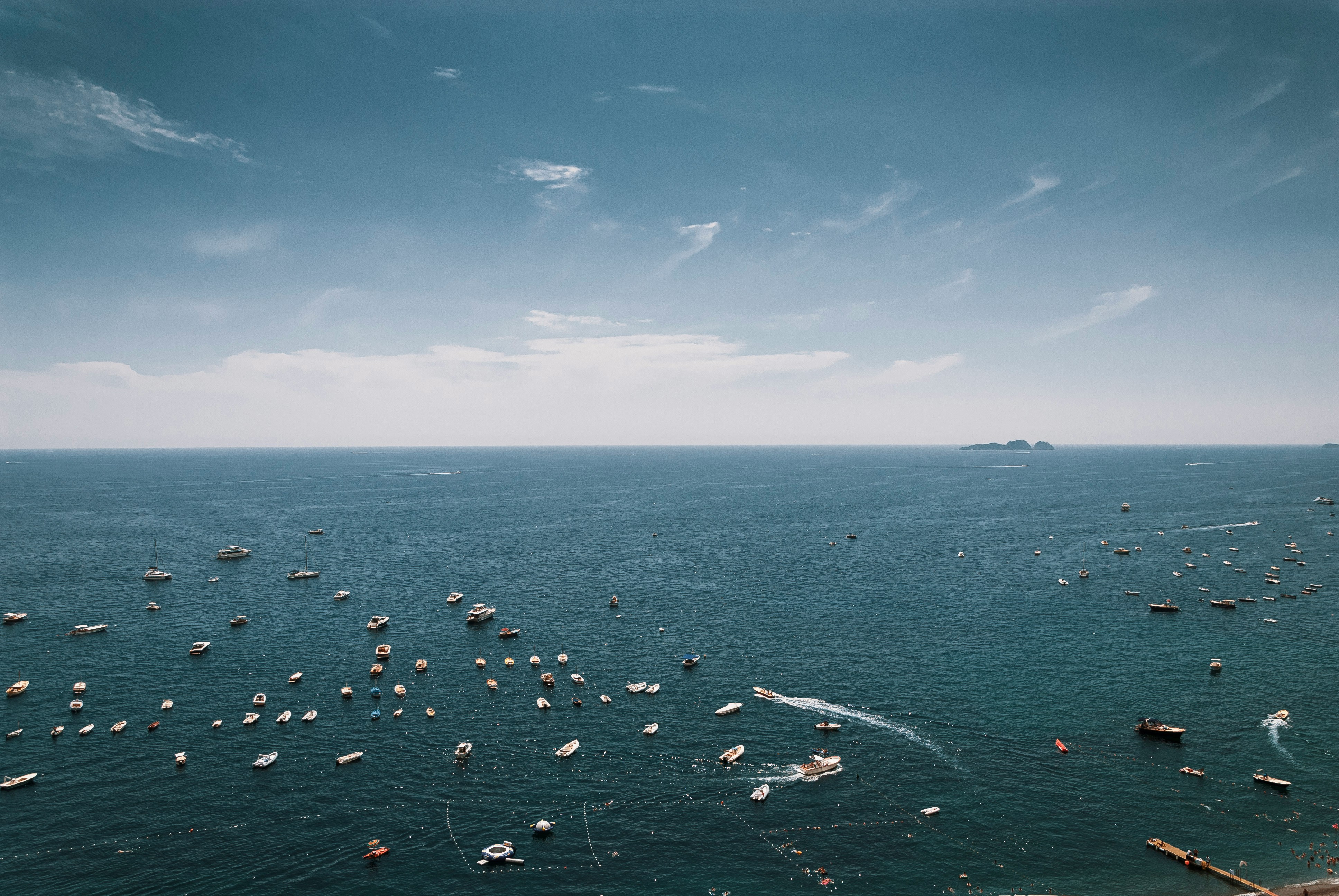 Photo by Unsplash An illustrative photo of white boats on a sea under blue sky.