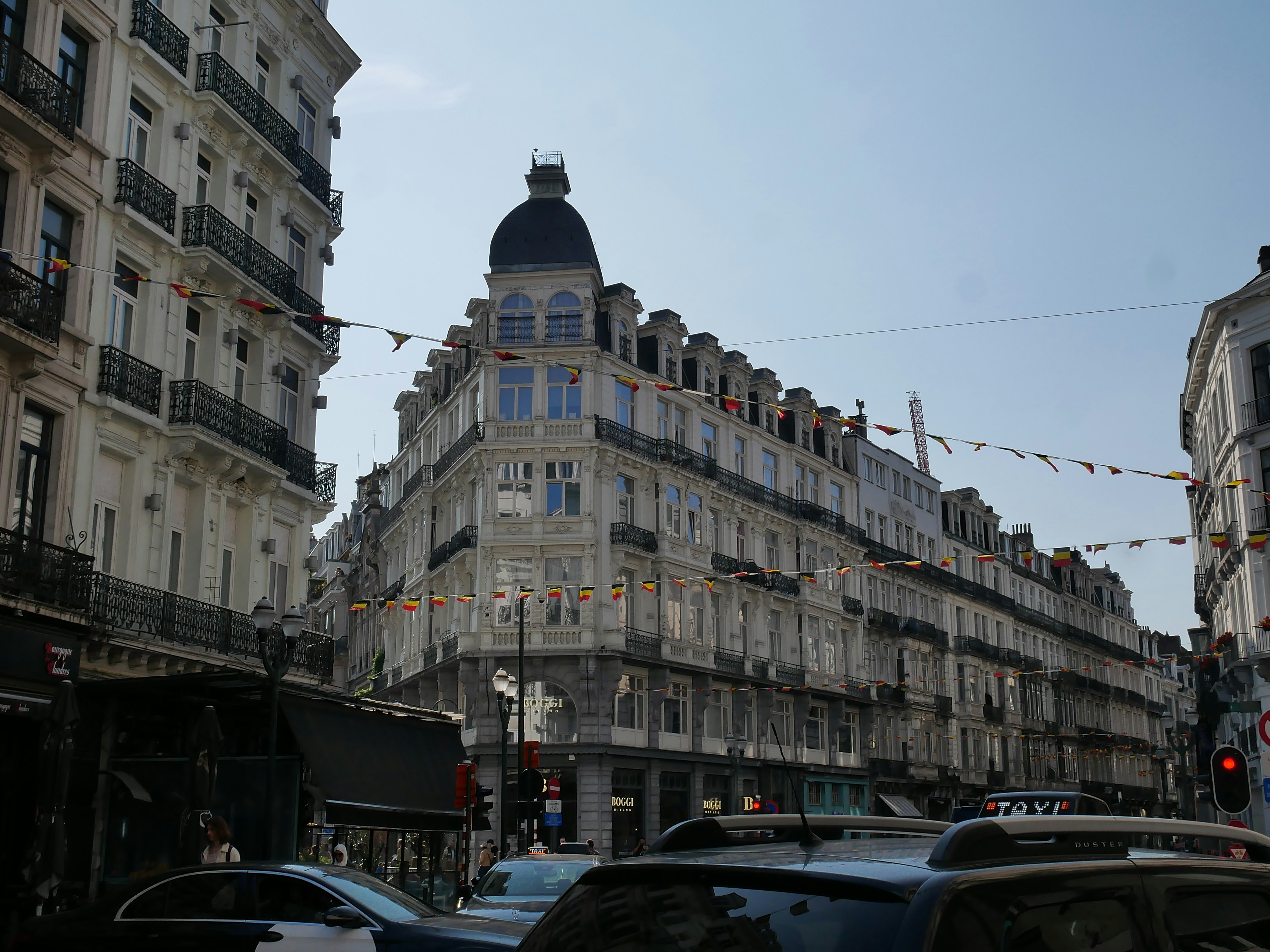 An illustrative photo of a city street filled with lots of cars between tall buildings.
