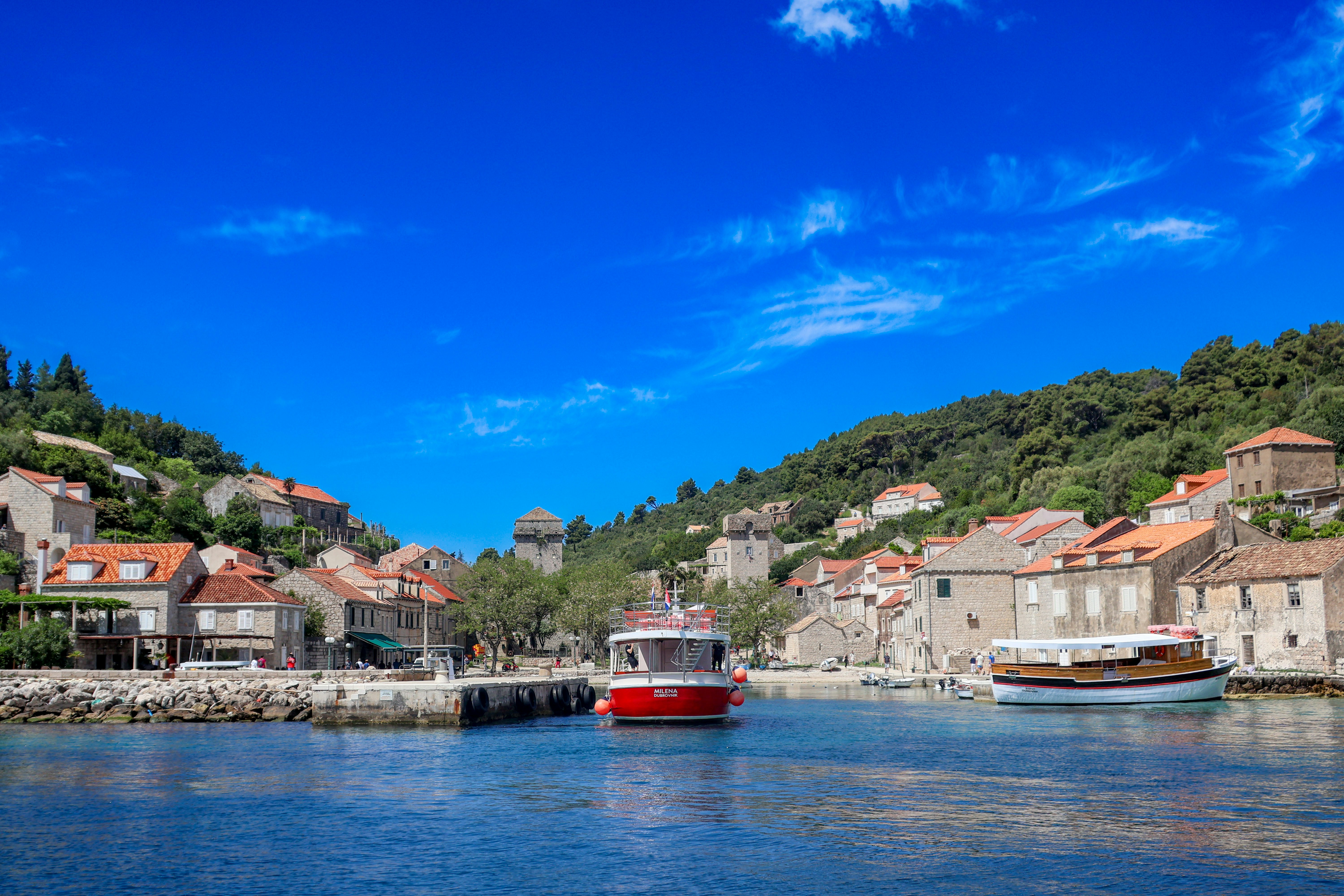 Photo by Unsplash An illustrative photo of a red boat in a body of water next to a village.