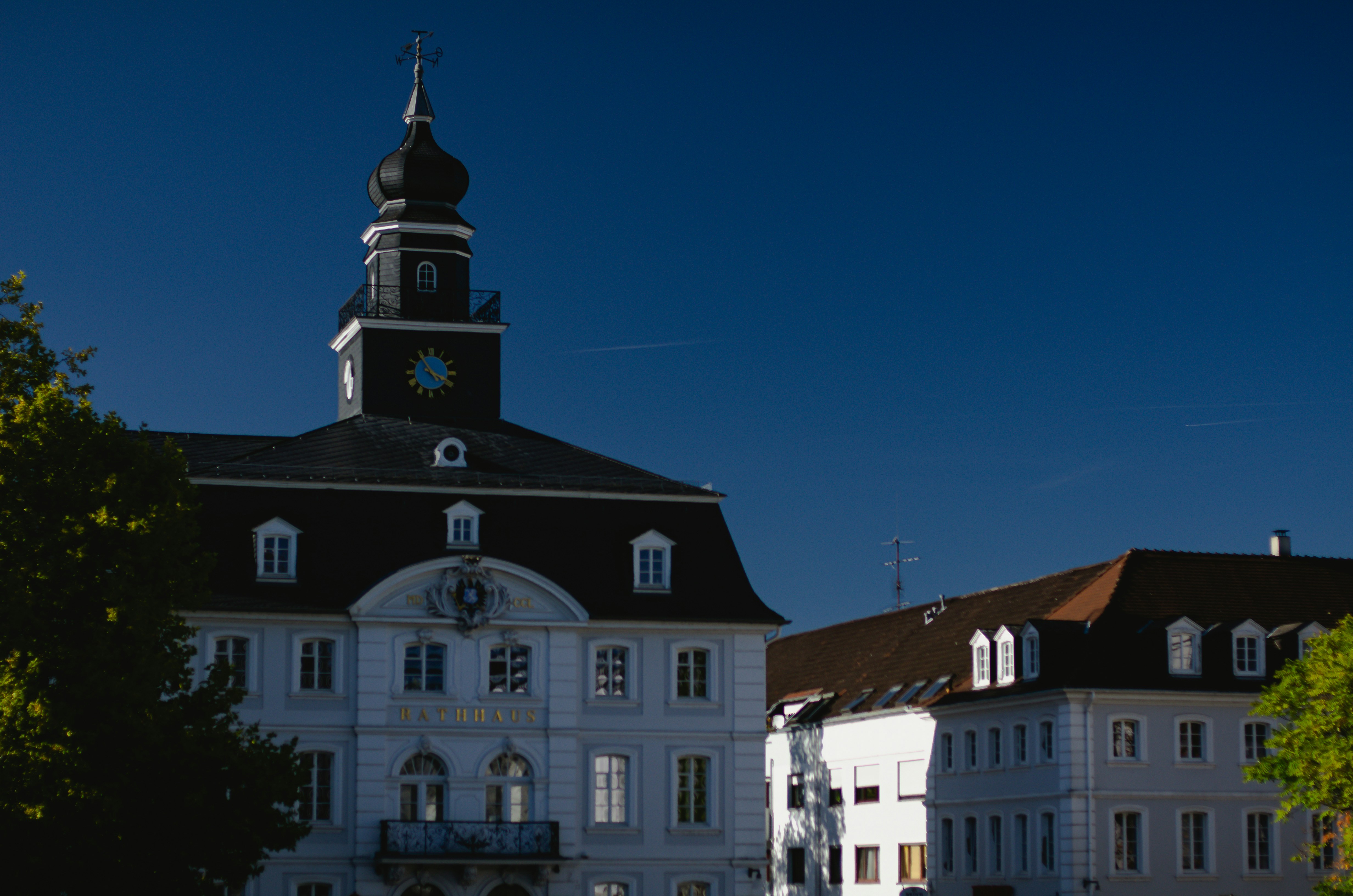 An illustrative photo of a large white building with a clock tower.