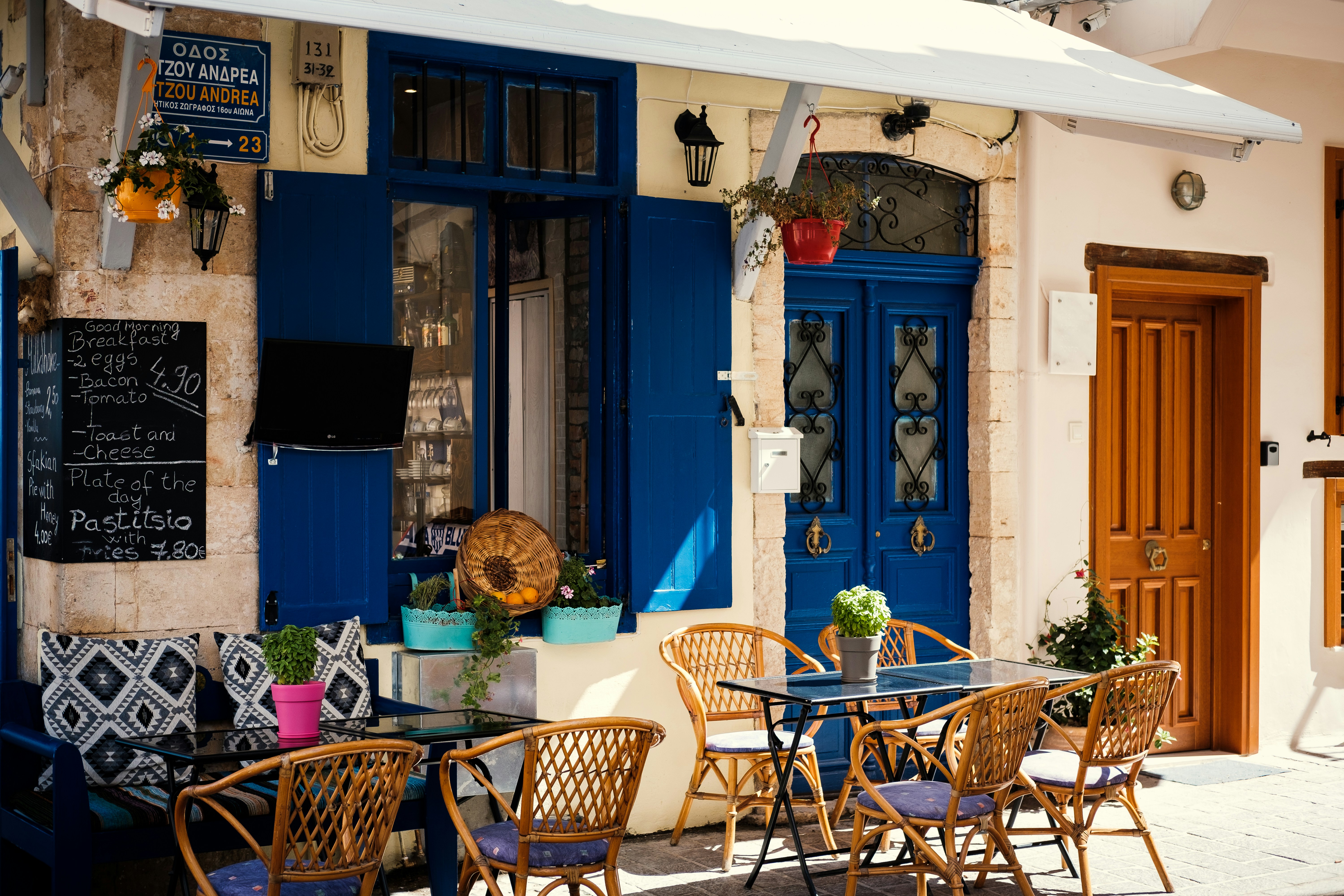 Photo by Unsplash An illustrative photo of armchairs outside a café with blue doors.