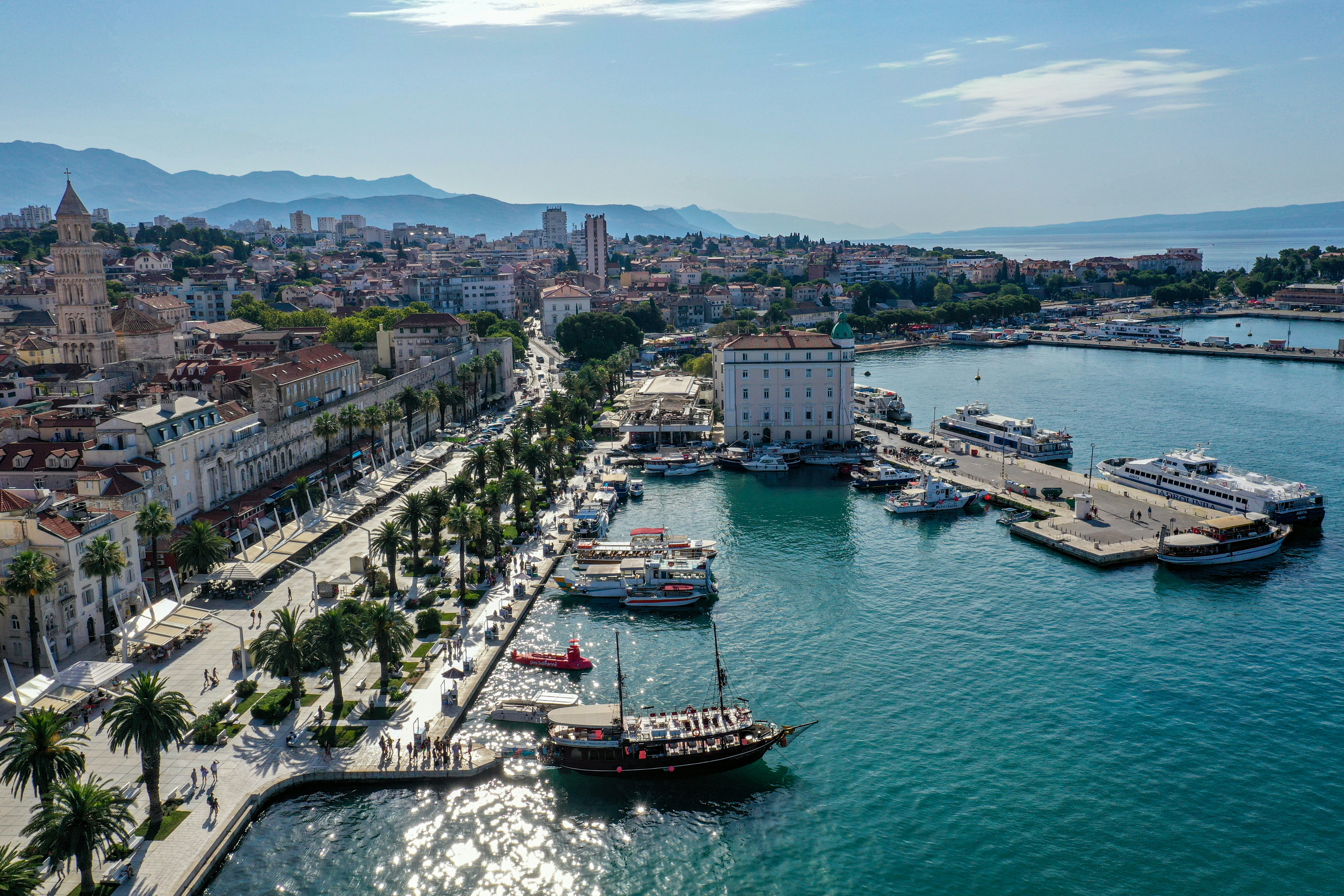 An illustrative photo of boats in a sea near a city.