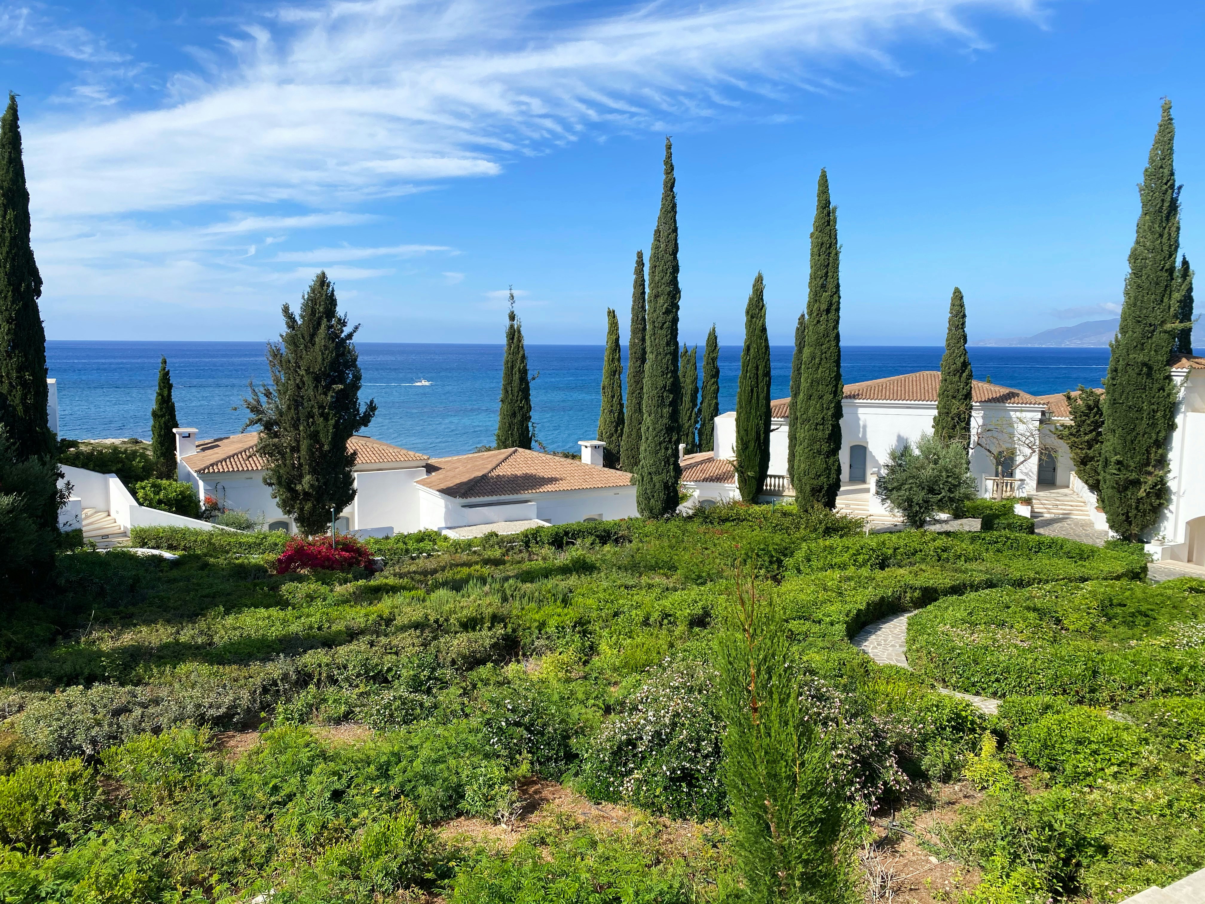 Photo by Unsplash An illustrative photo of white houses on a green coast near a sea.