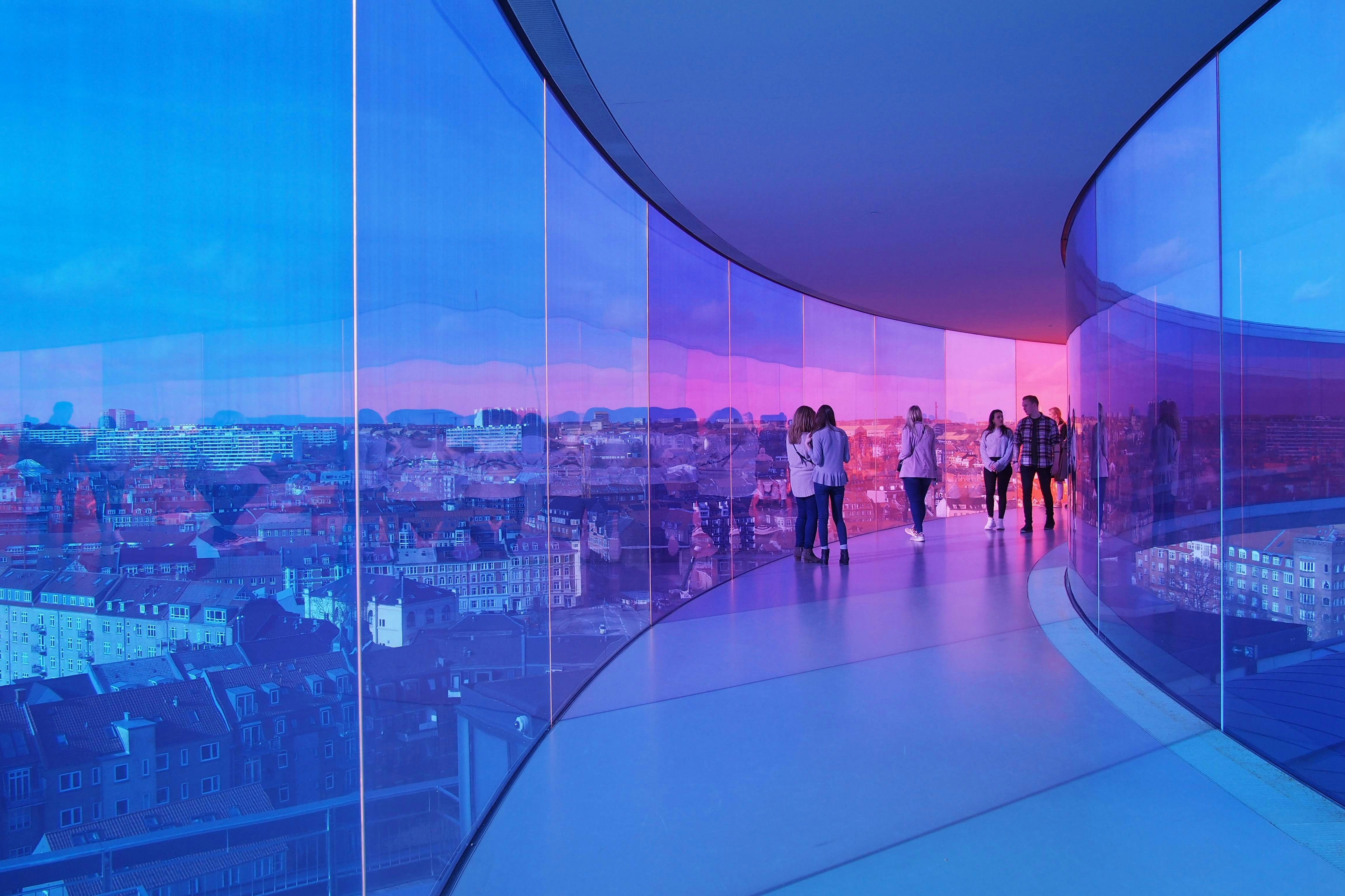 An illustrative photo of people walking in a glass tunnel. 